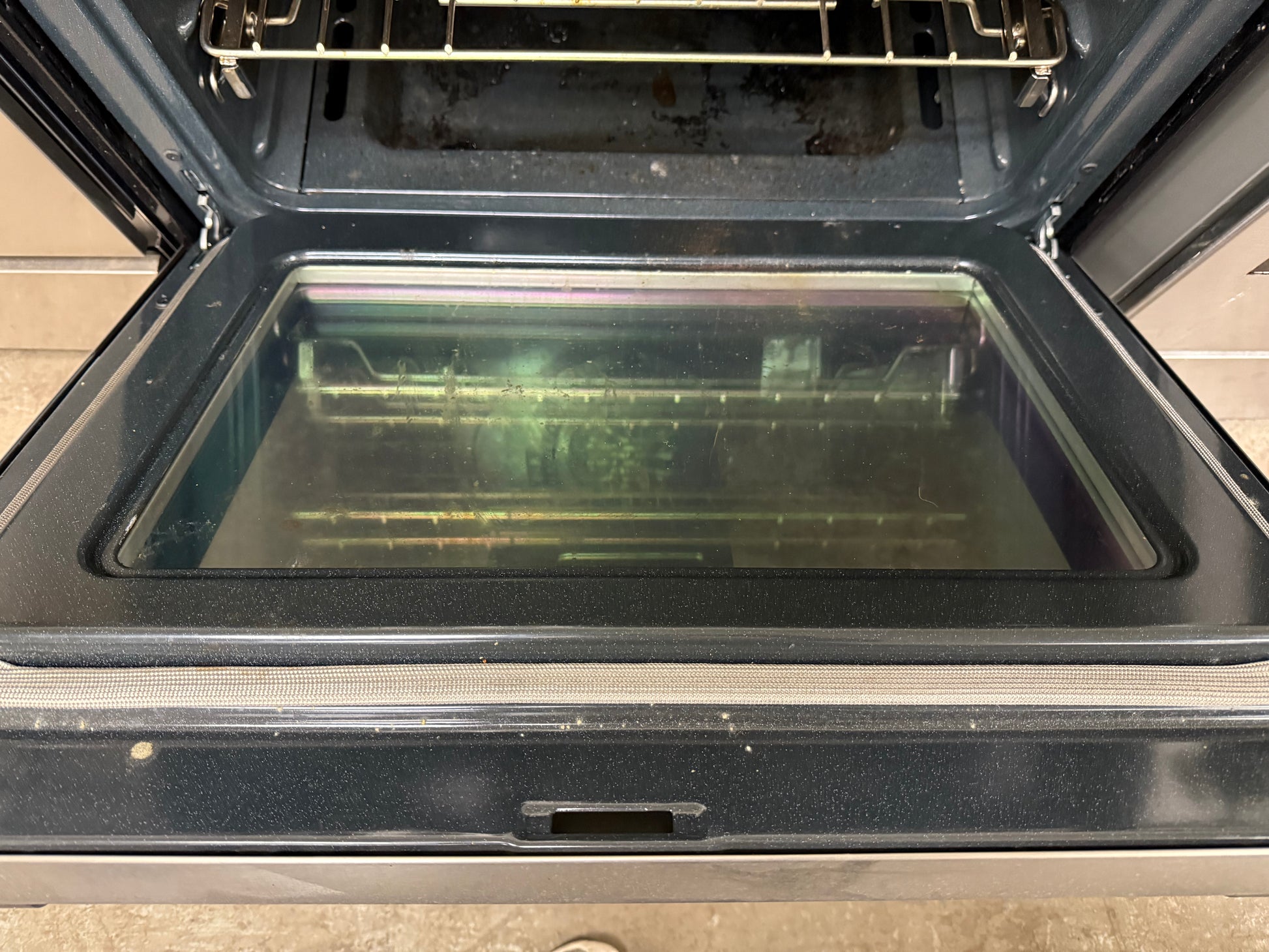 Open oven with a glass door on a wooden floor