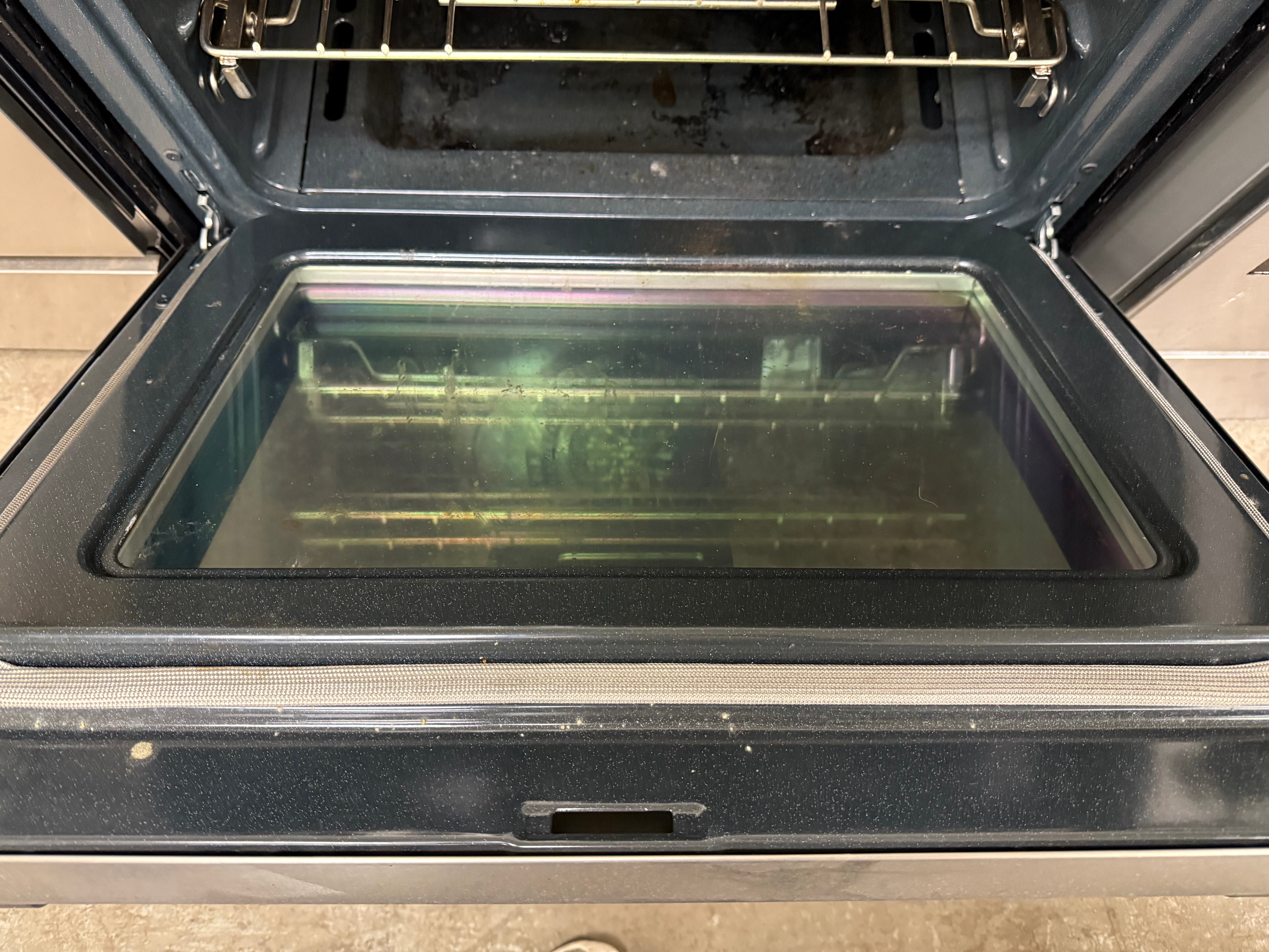 Open oven with a glass door on a wooden floor