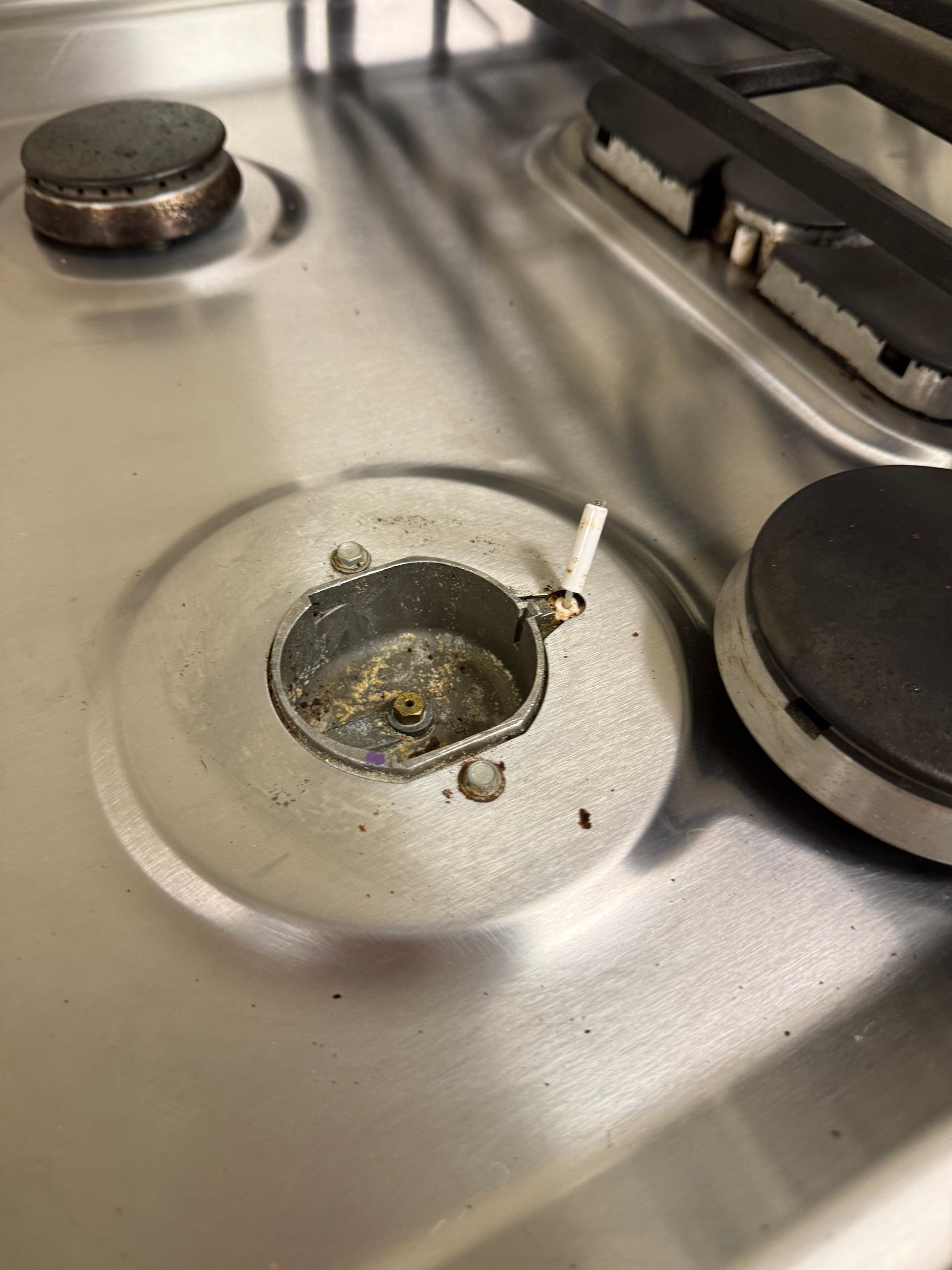 Stove burner with a lit match on a metallic surface