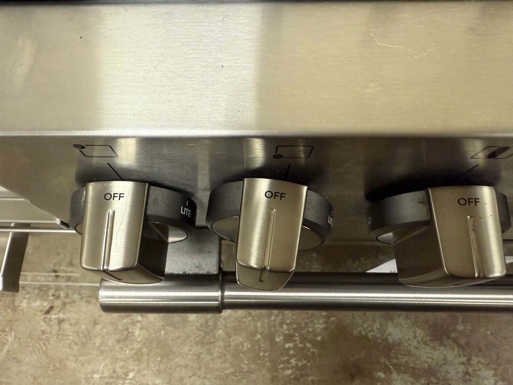 Close-up of three gas stove knobs on a metallic surface