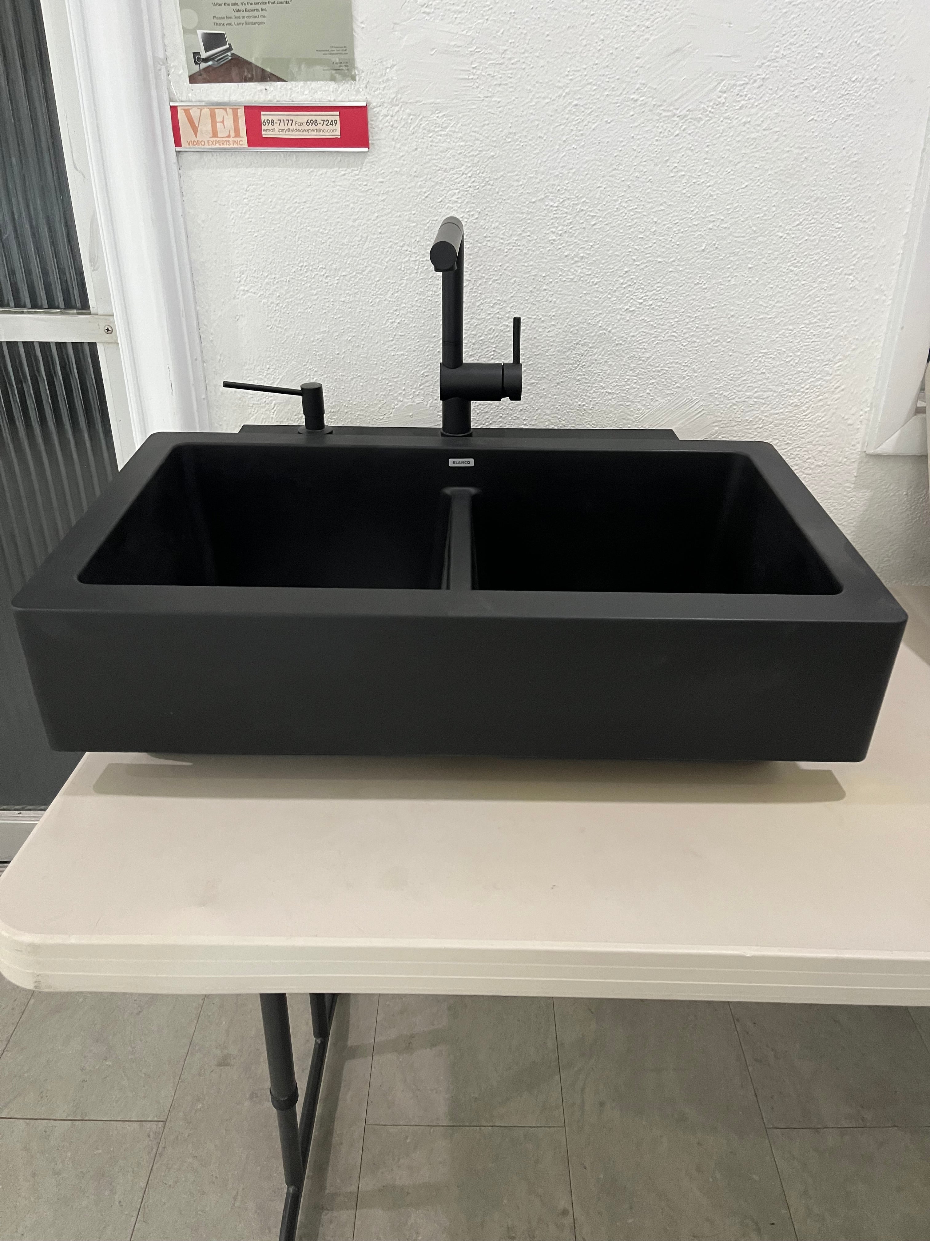 Black wall-mounted cabinet in a modern bathroom setting