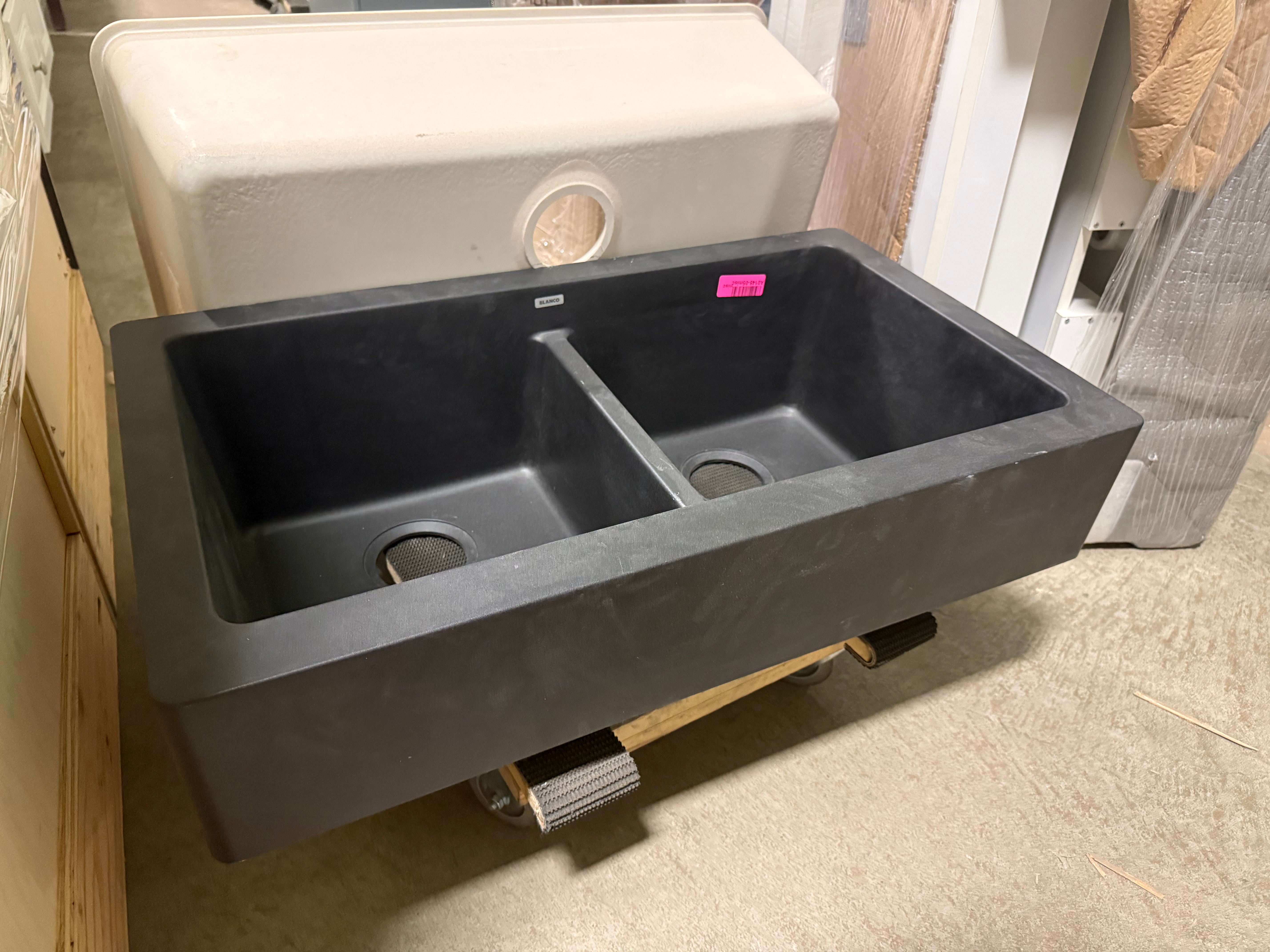 Gray kitchen sink on display with a price tag in a store setting