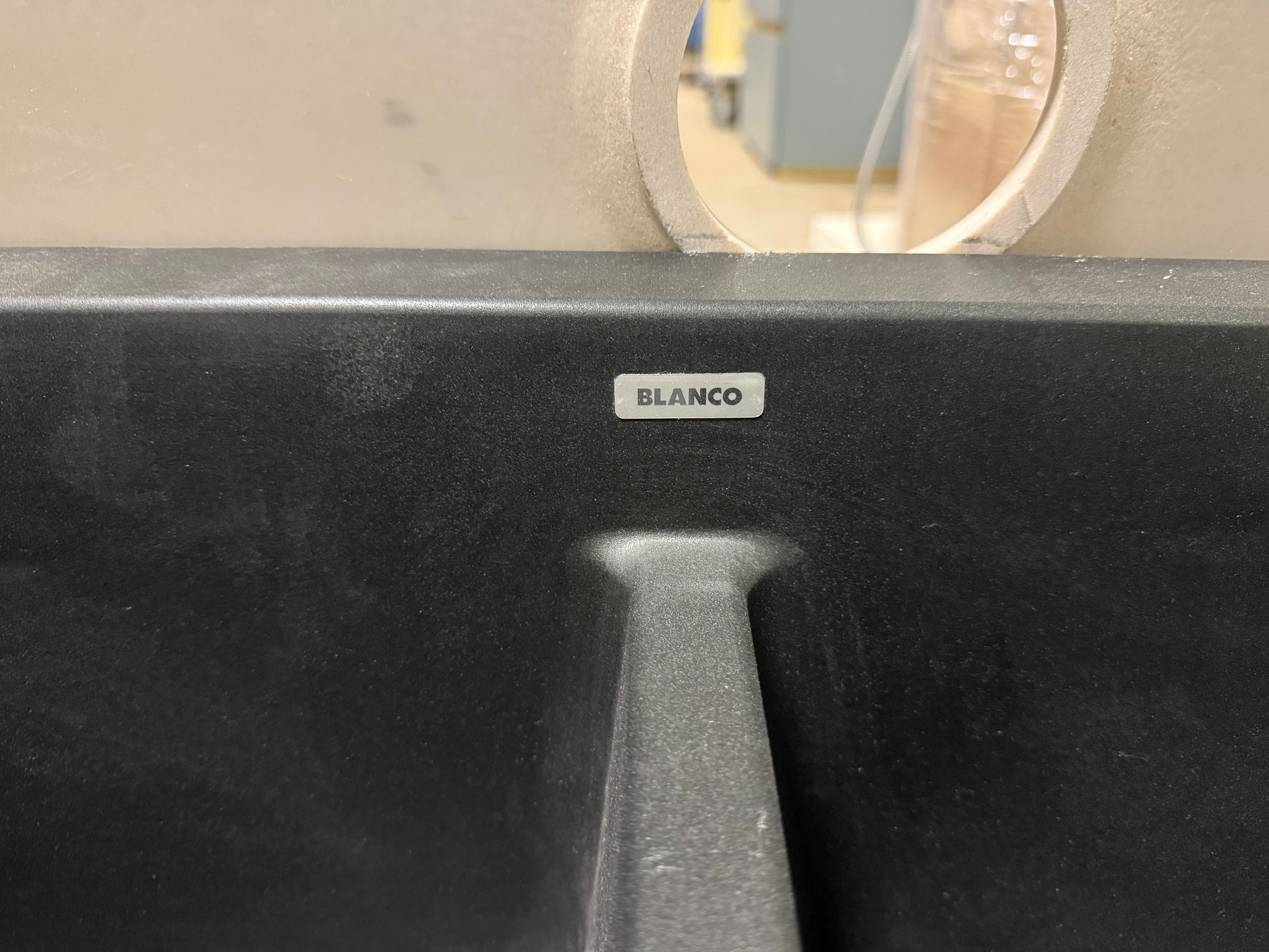 Black kitchen sink with BLANCO logo on a neutral background
