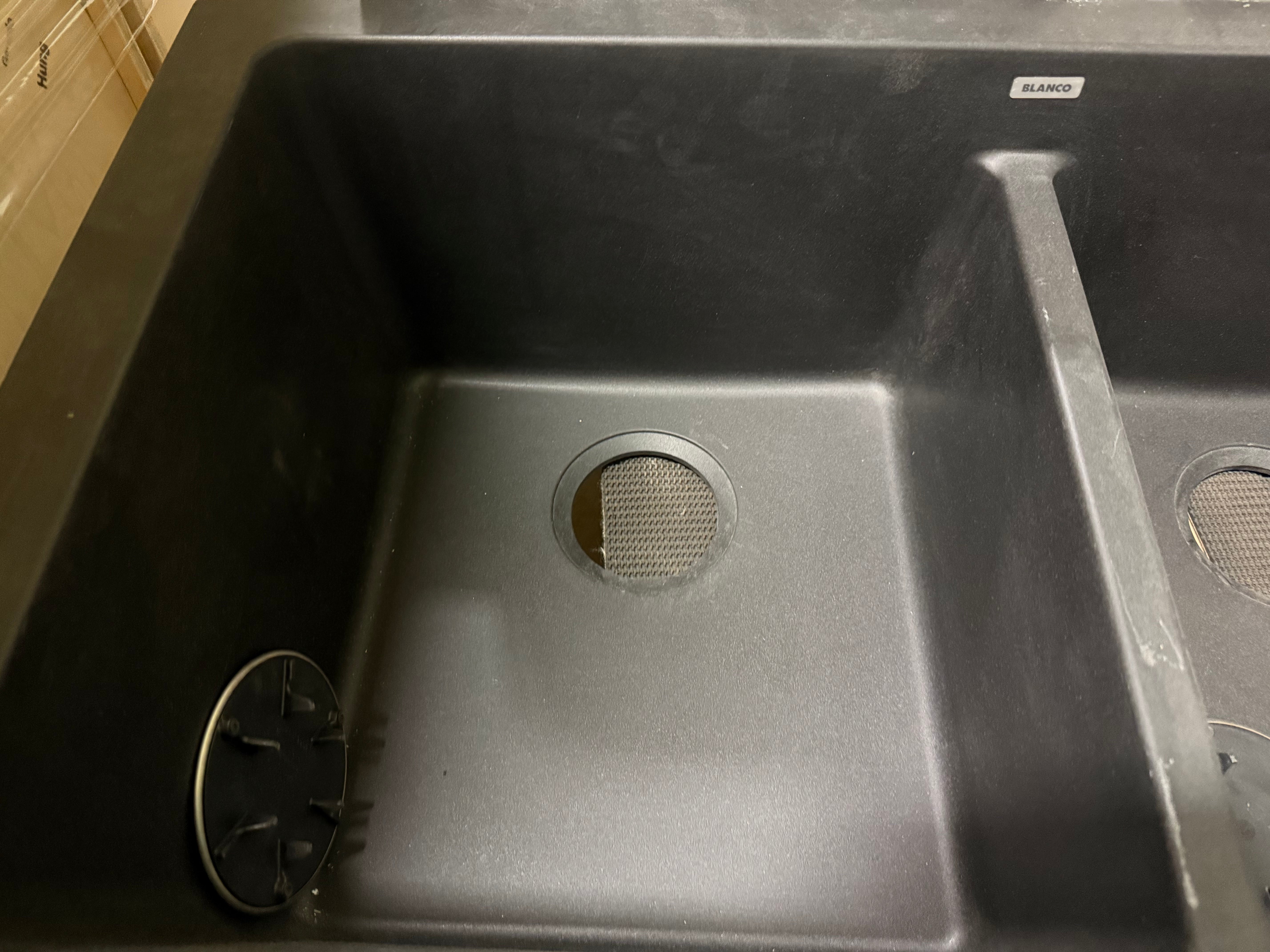 Black kitchen sink with visible brand name on a countertop