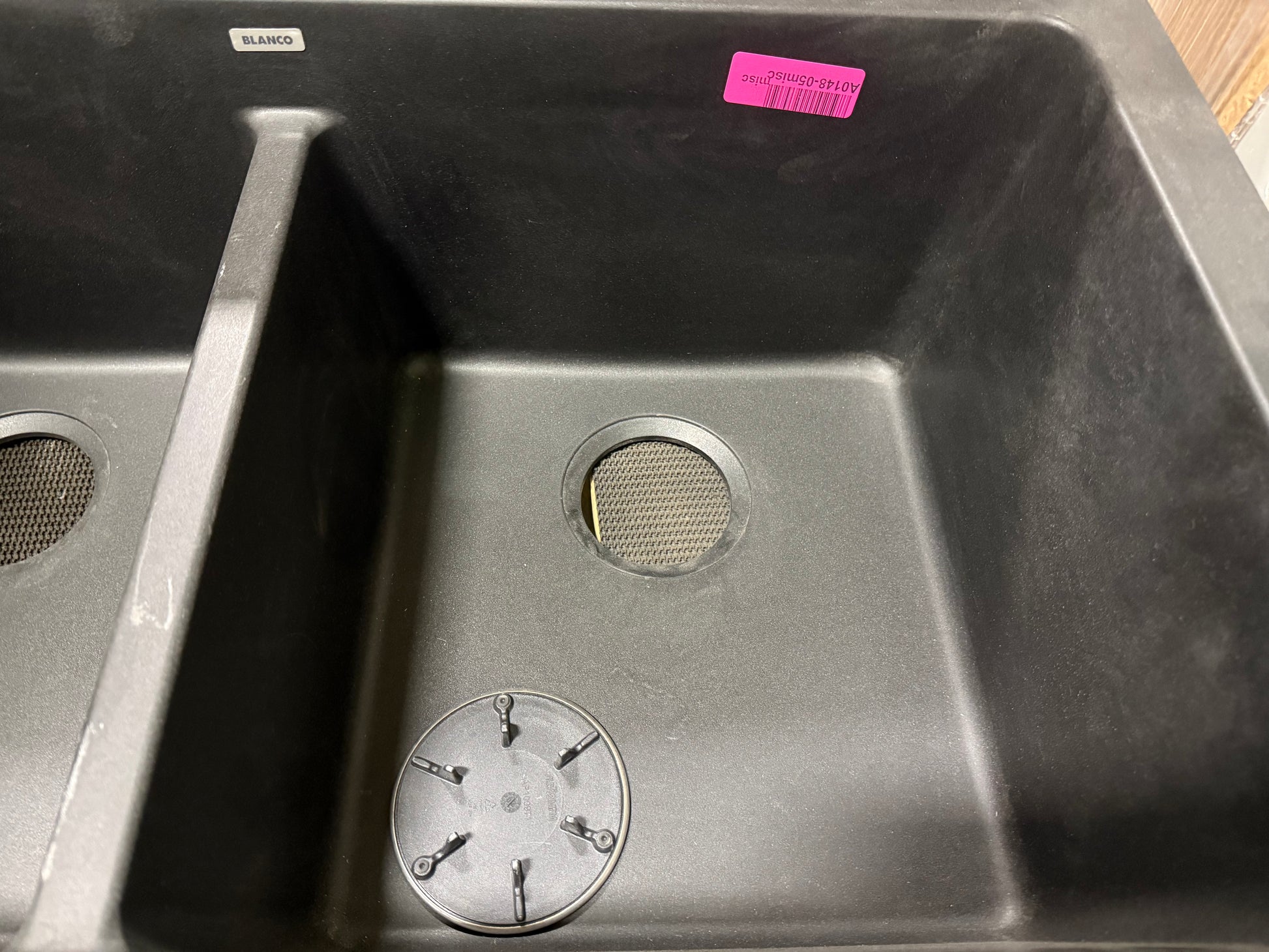 Stainless steel kitchen sink with visible brand label