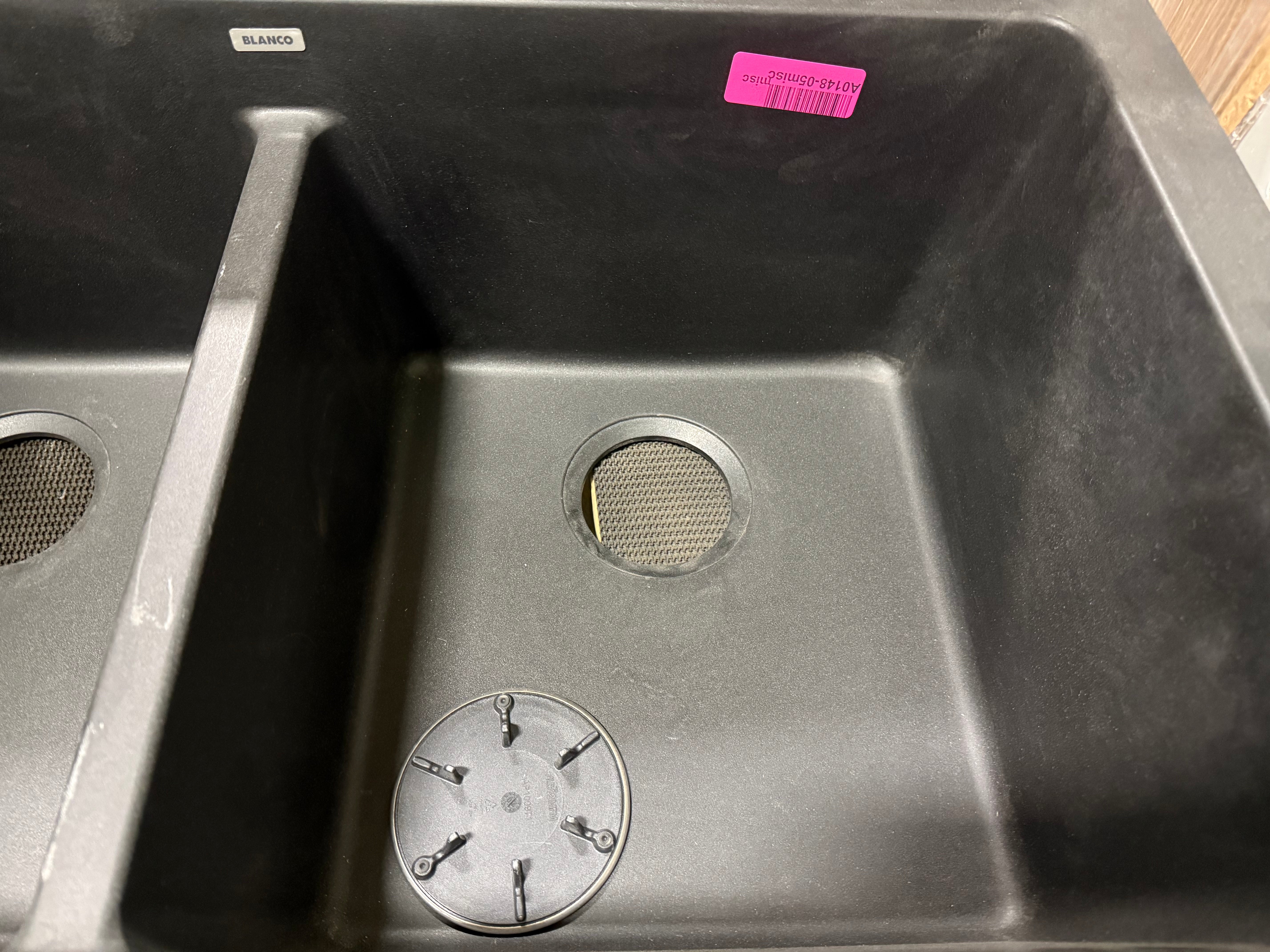 Stainless steel kitchen sink with visible brand label