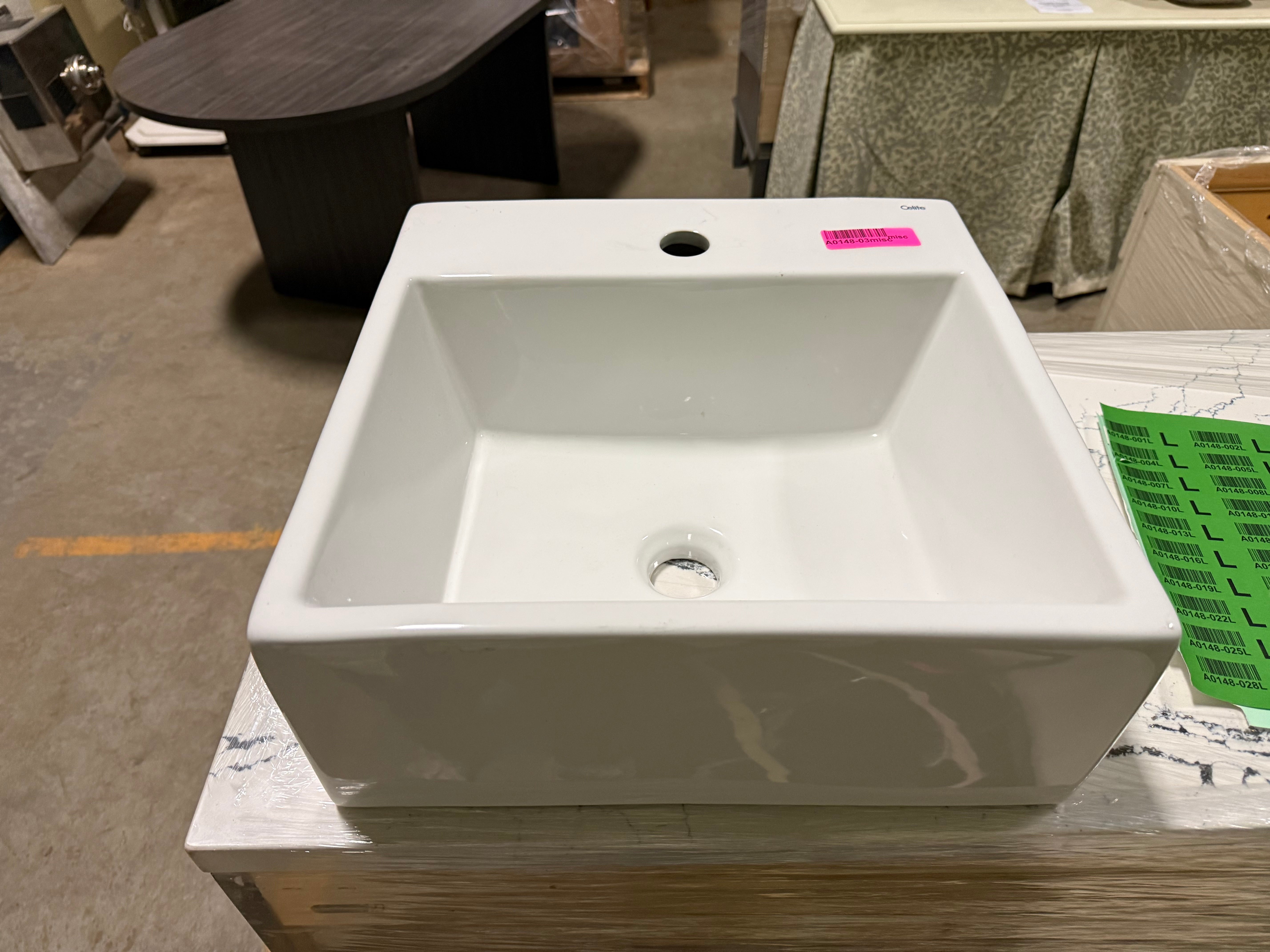 White rectangular sink on a wooden platform with a blurred background
