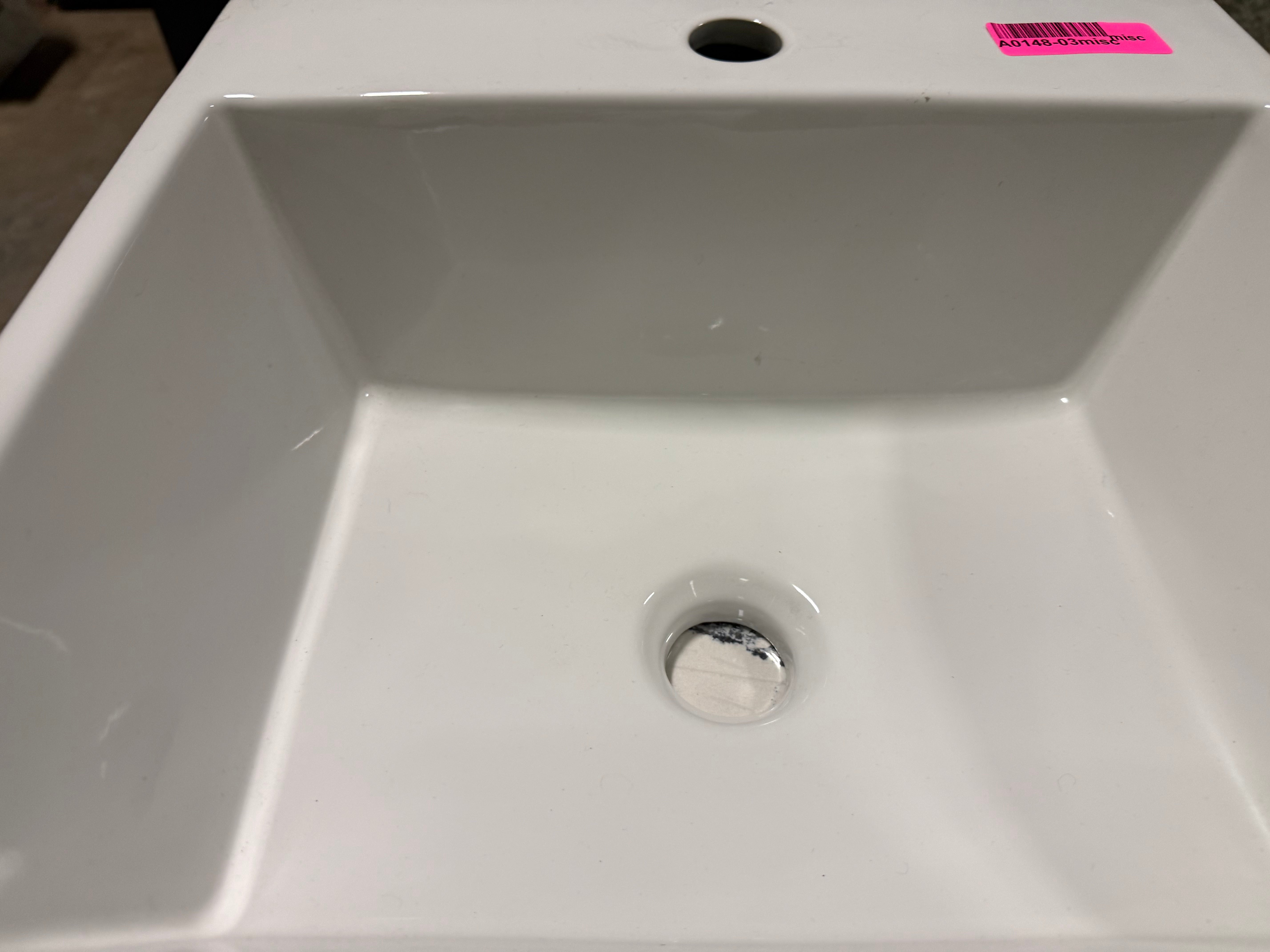 White ceramic sink with a drain in a showroom setting