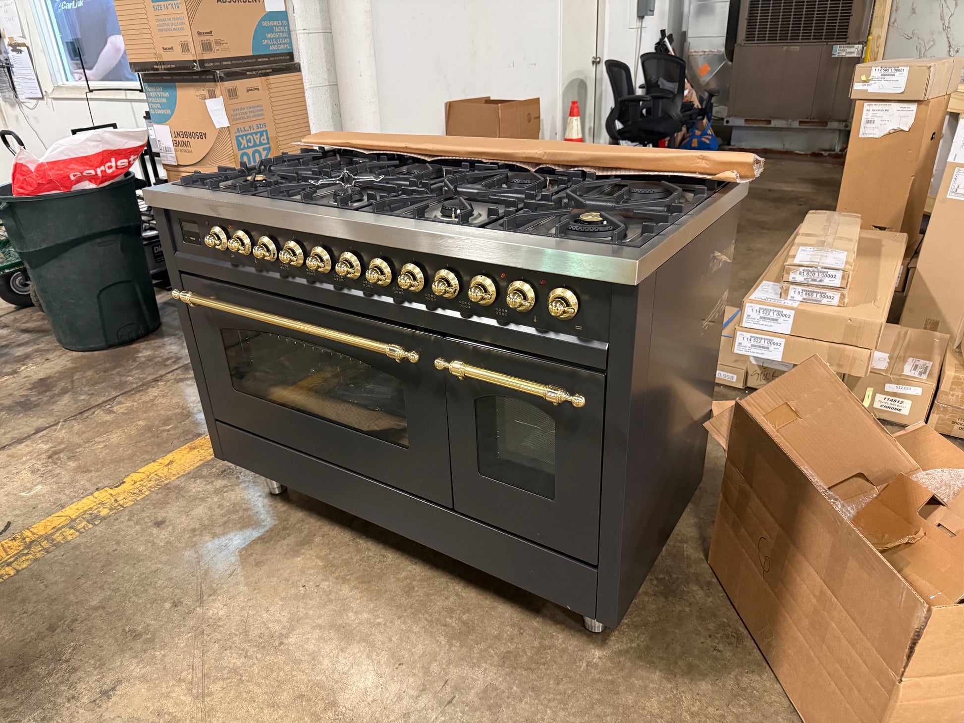 Showroom display 48 inch ILVE range displaying 8 black brass burners and continuous iron grates