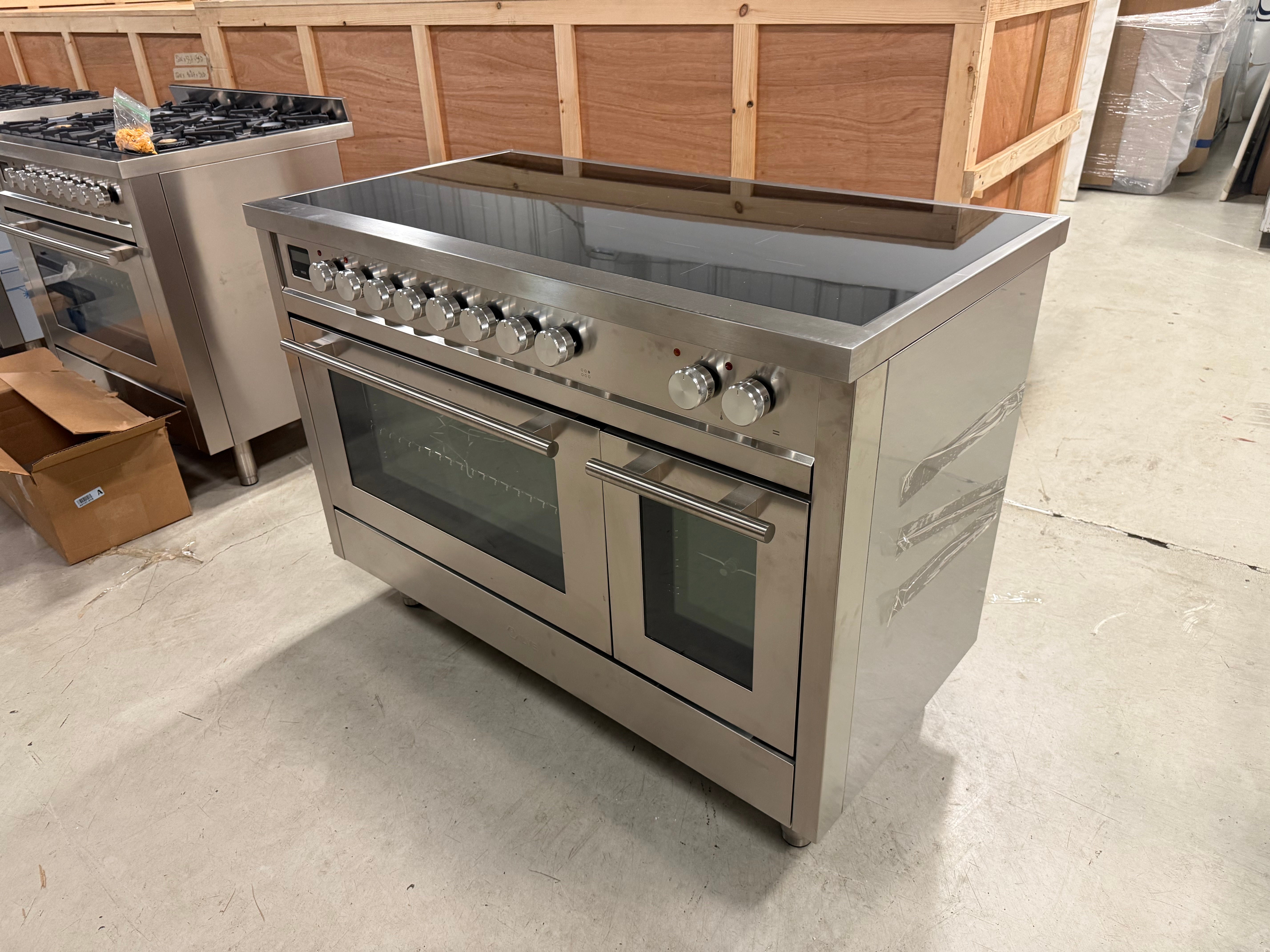 Showroom display 48 inch ILVE electric range showing 6 zone glass induction top and knobs