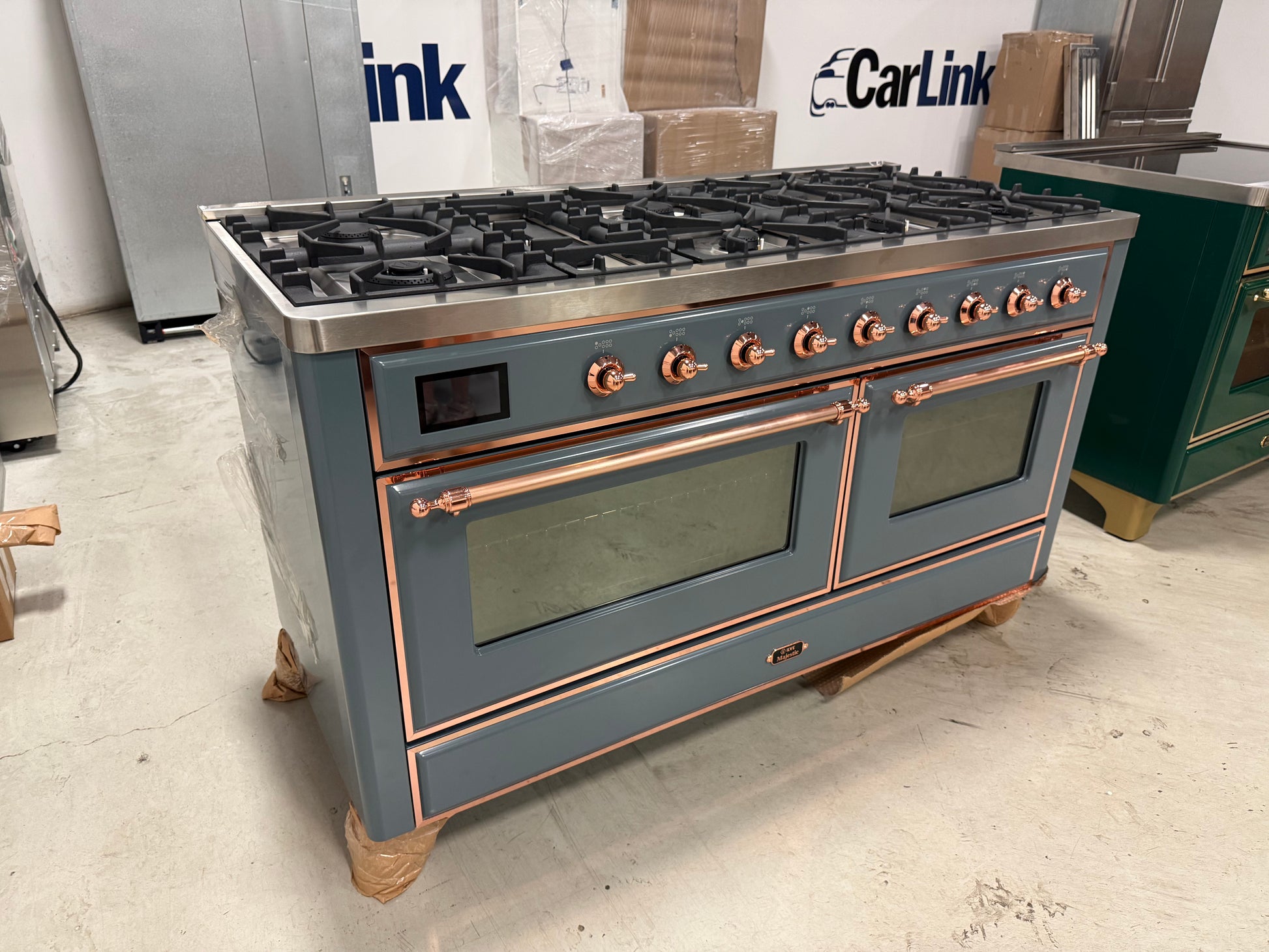 Showroom display 60 inch ILVE range displaying 9 black brass burners and central griddle top