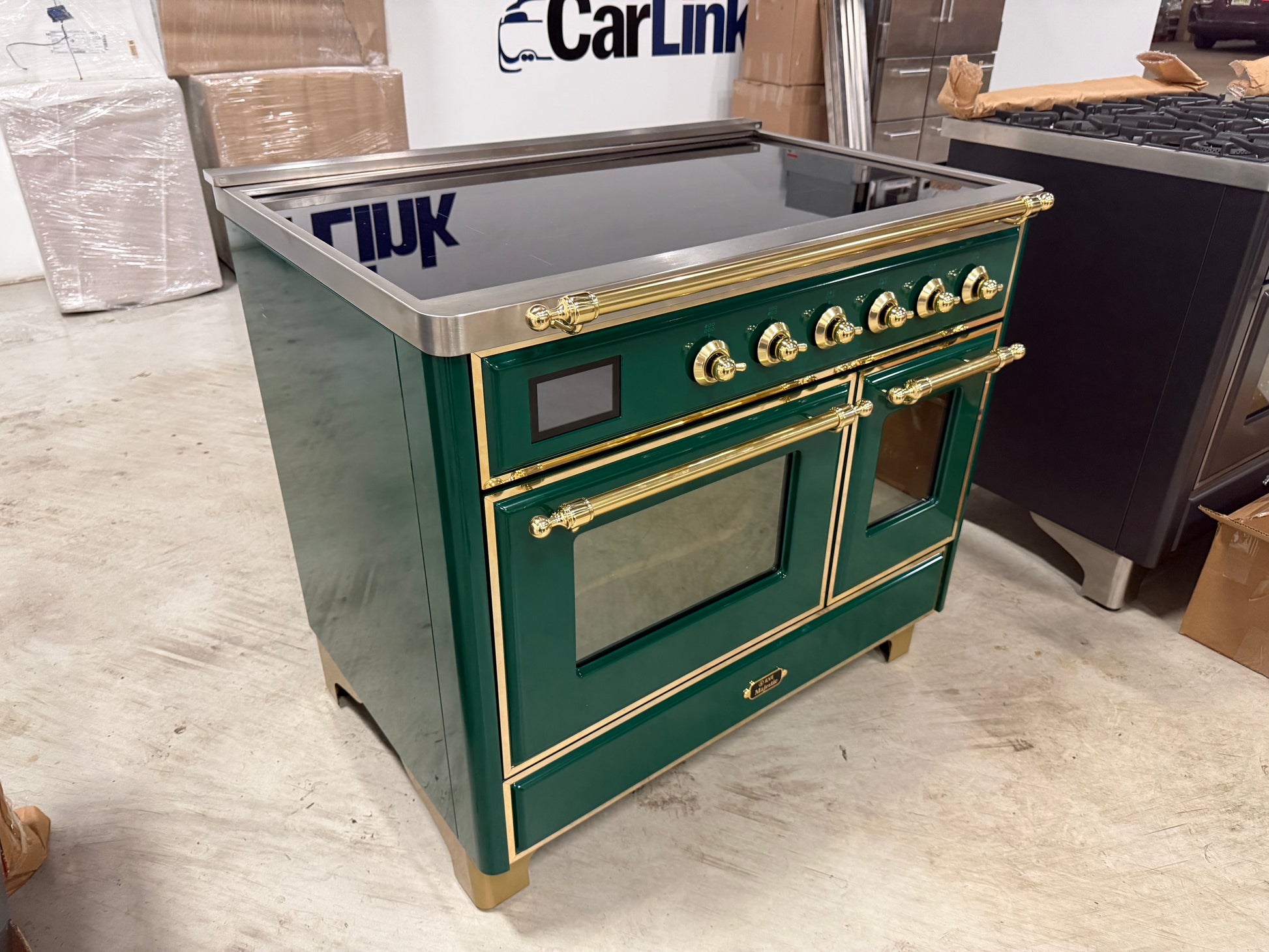 Showroom display 40 inch ILVE electric range showing 6 element glass induction top and brass accents
