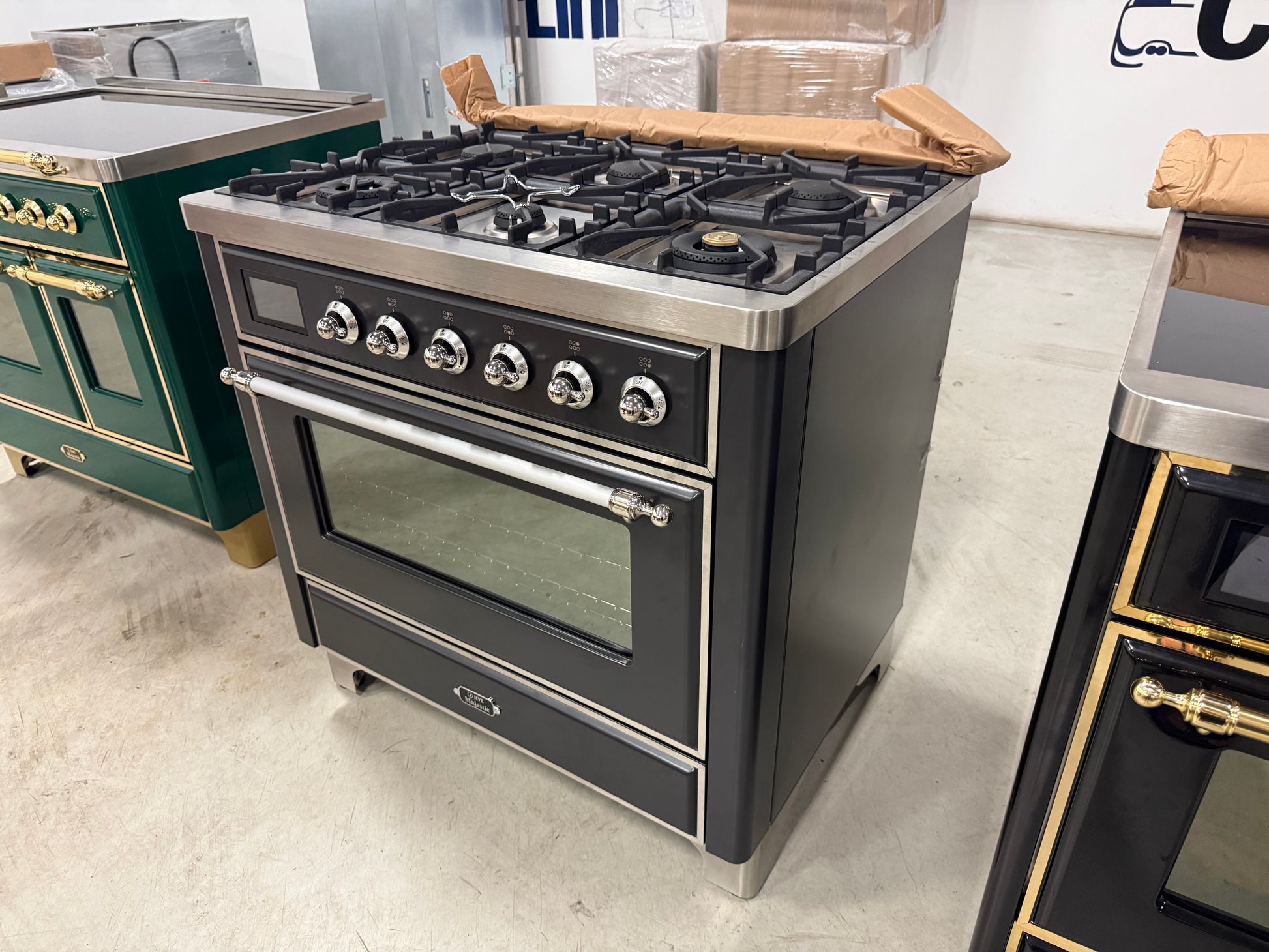 Showroom display ILVE 36 range displaying 6 matte black brass burners and continuous iron grates