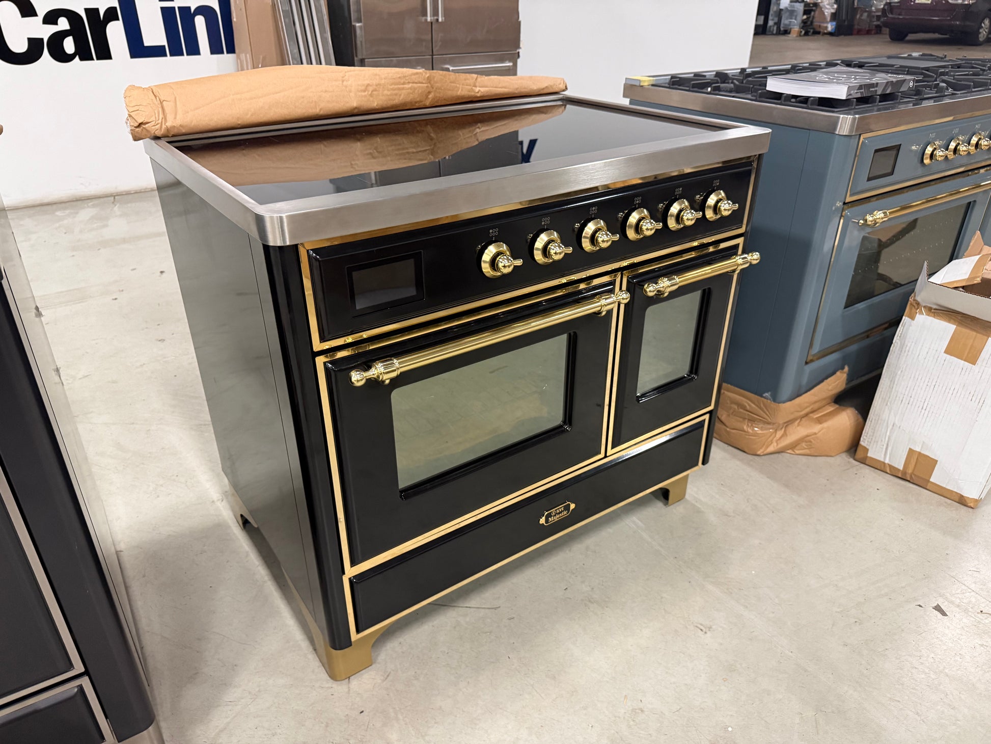 Showroom display 40 inch ILVE electric range showing 6 element glass induction top and brass accents