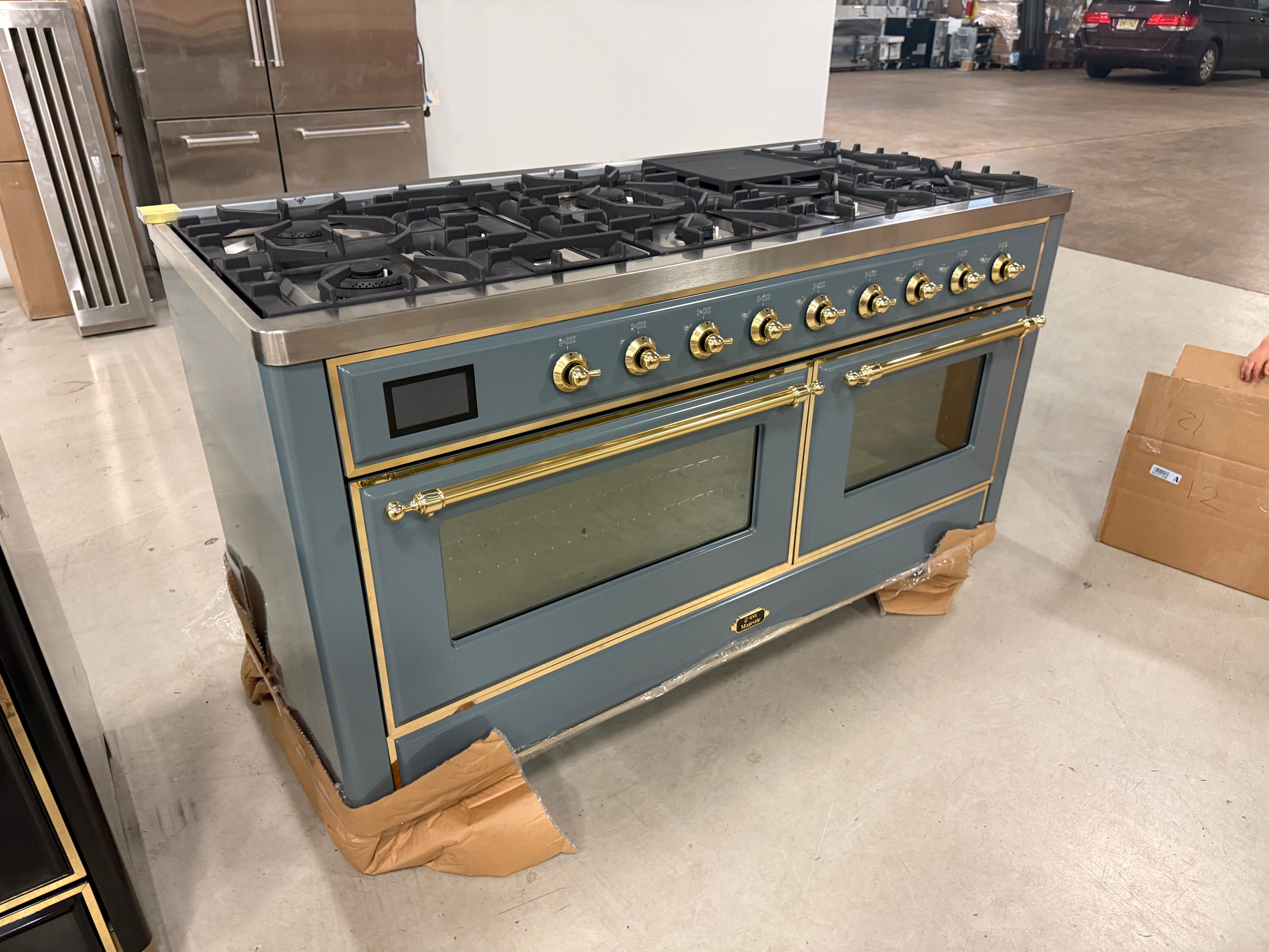 Showroom display 60 inch ILVE range displaying 9 black brass burners and central griddle top