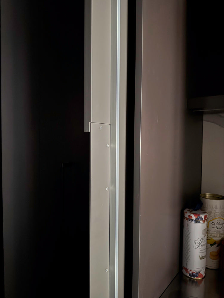 Close-up of a kitchen cabinet with a can inside, on a dark background