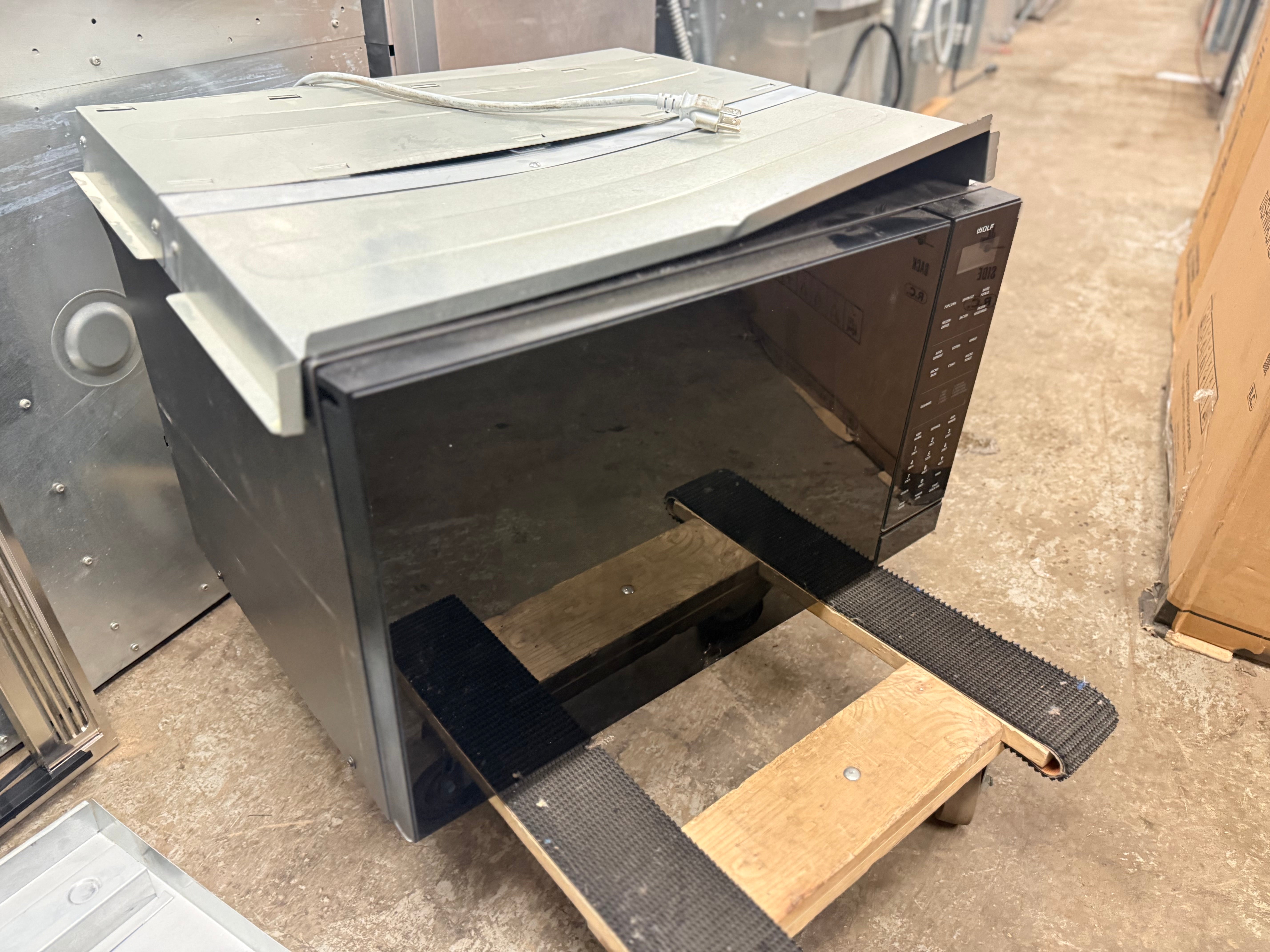 Wolf 24 inch microwave built into kitchen cabinetry using 30 inch E series stainless steel trim kit
