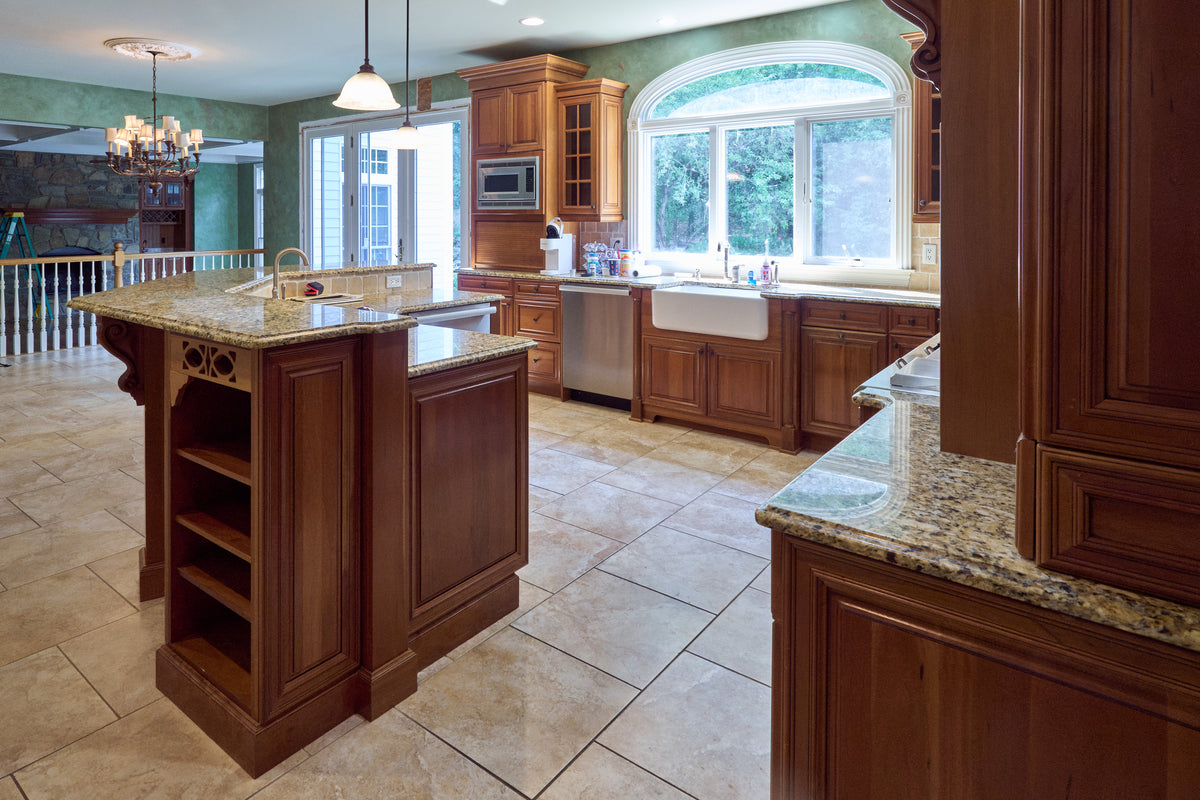 Aurora Circ traditional wood kitchen with raised panel cabinets granite countertops central island farmhouse sink and built in appliances