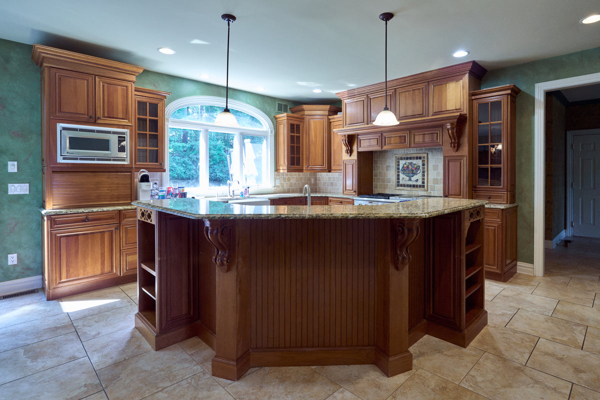 Aurora Circ traditional wood kitchen with ornate cabinetry granite island built-in microwave and decorative range hood