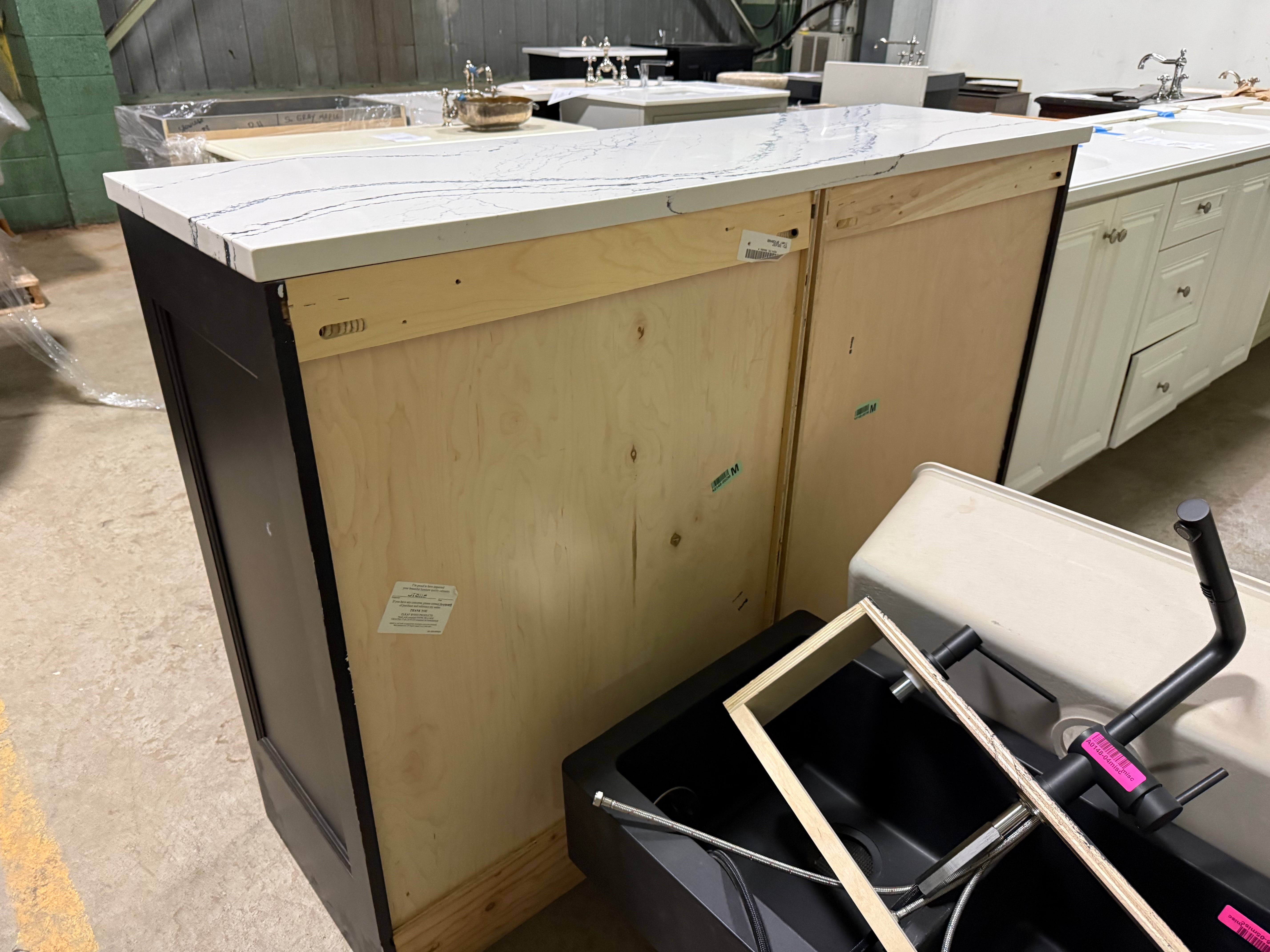 Under-construction kitchen island with wooden backer and white countertop.