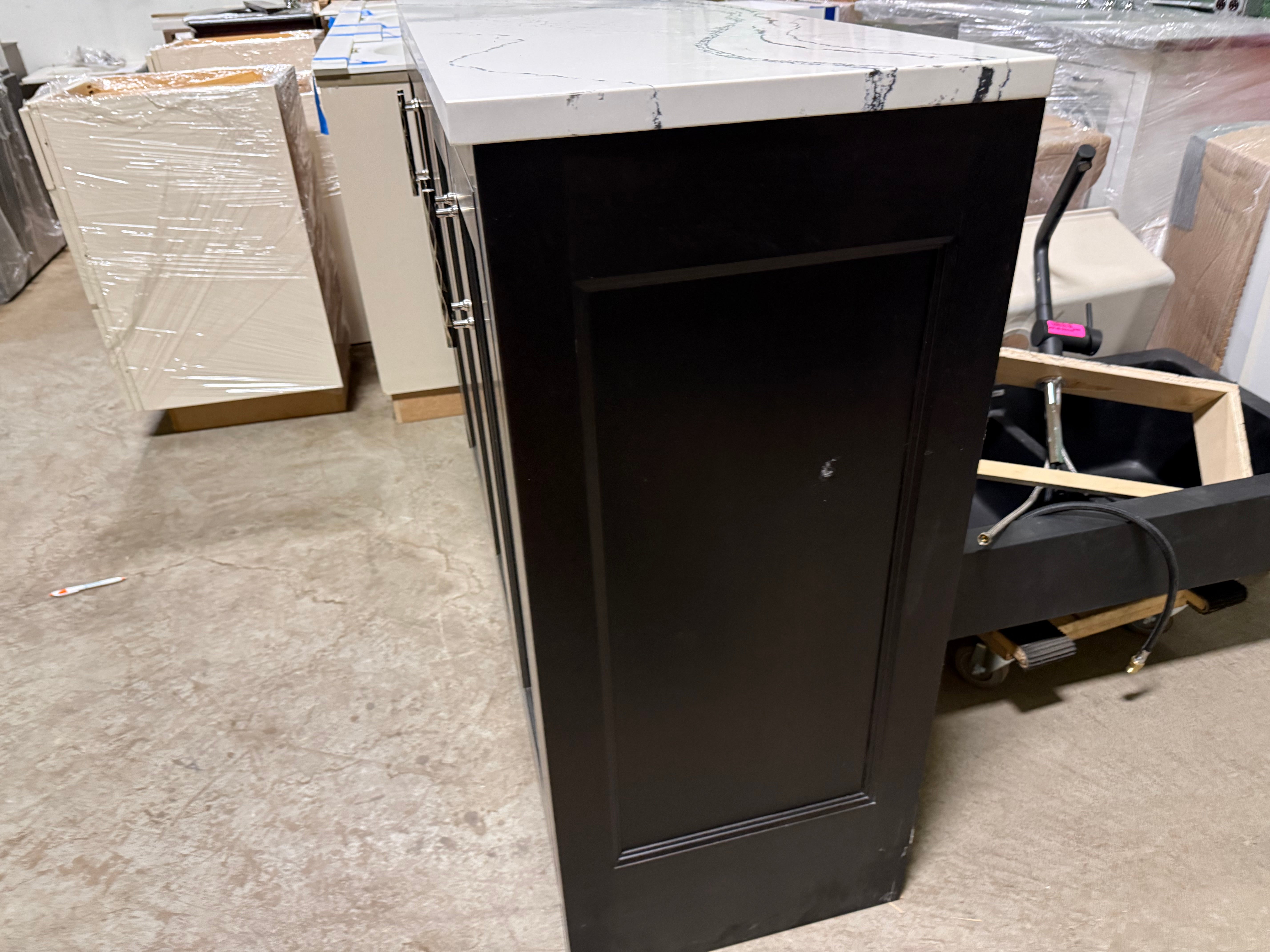 Black cabinet with marble countertop in a warehouse setting