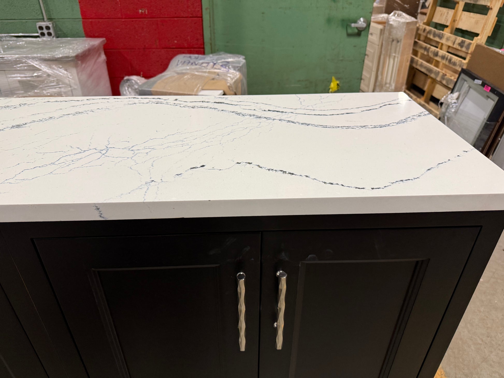 Black cabinet with marble-like countertop in a workshop setting