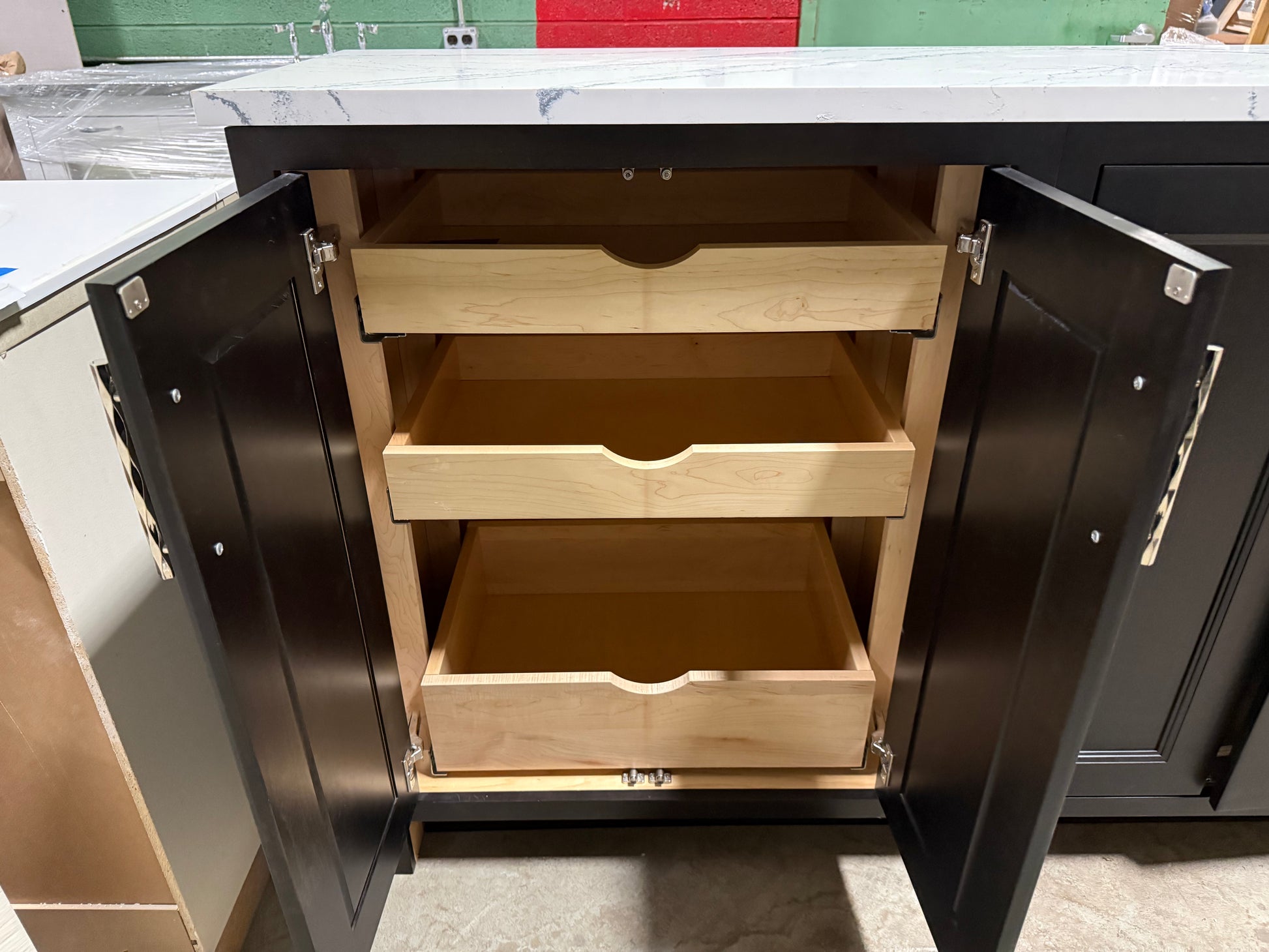 Kitchen cabinet with open drawers showing wooden shelves