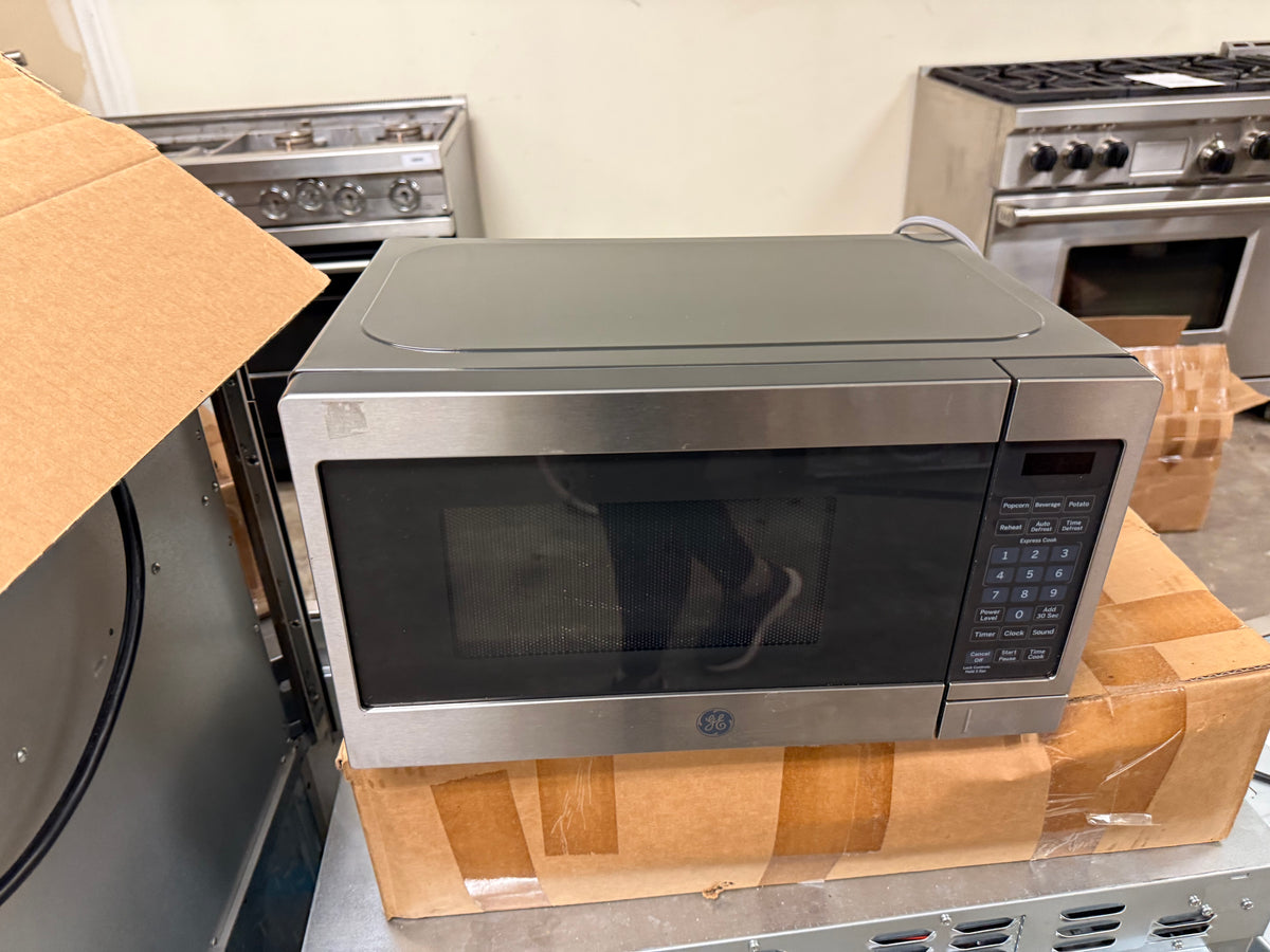 Small residential kitchen microwave with digital touch pad and glass door