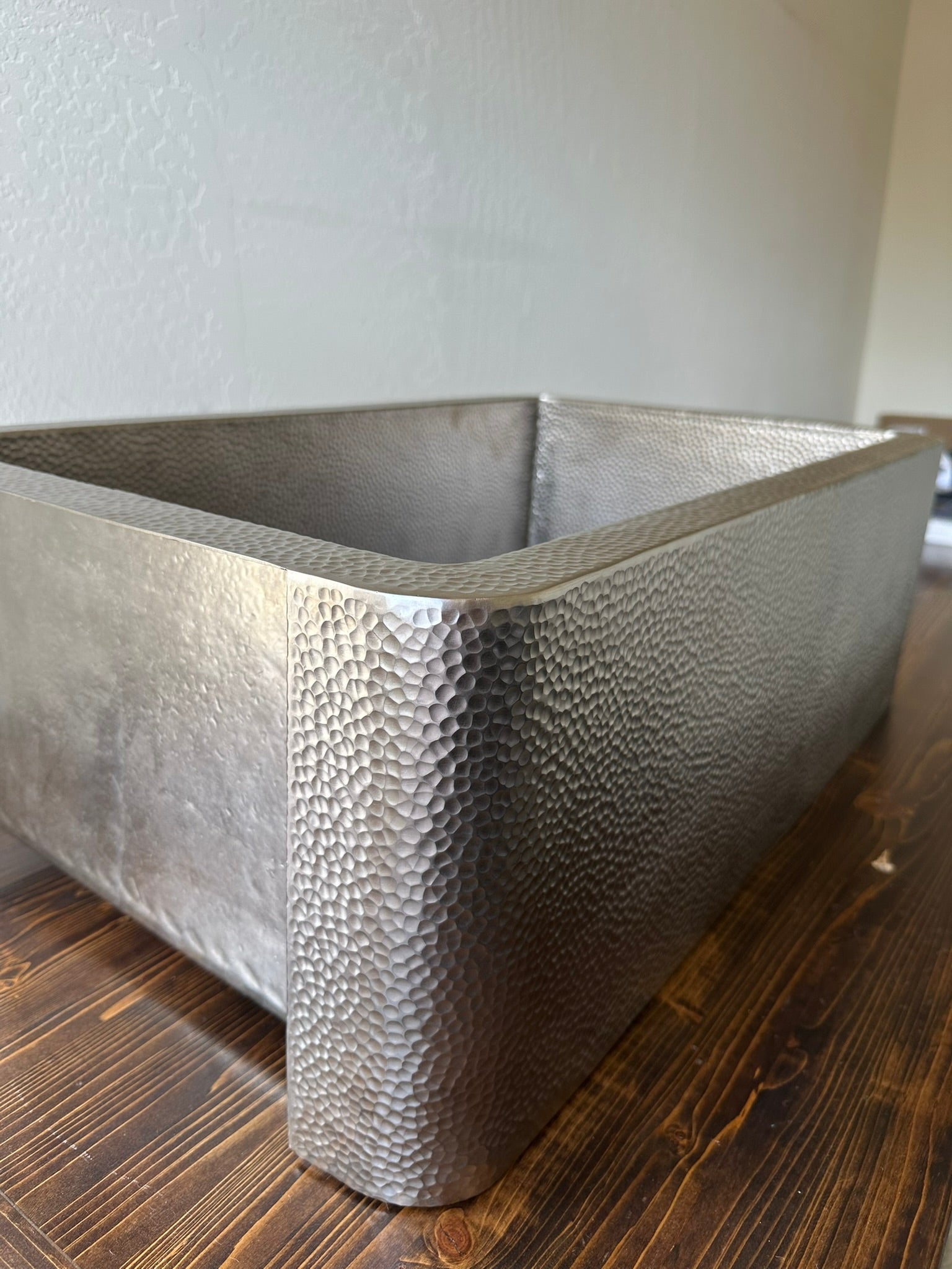 Detail shot of artisan hand-hammered texture on a Native Trails Brushed Nickel over copper apron front sink.