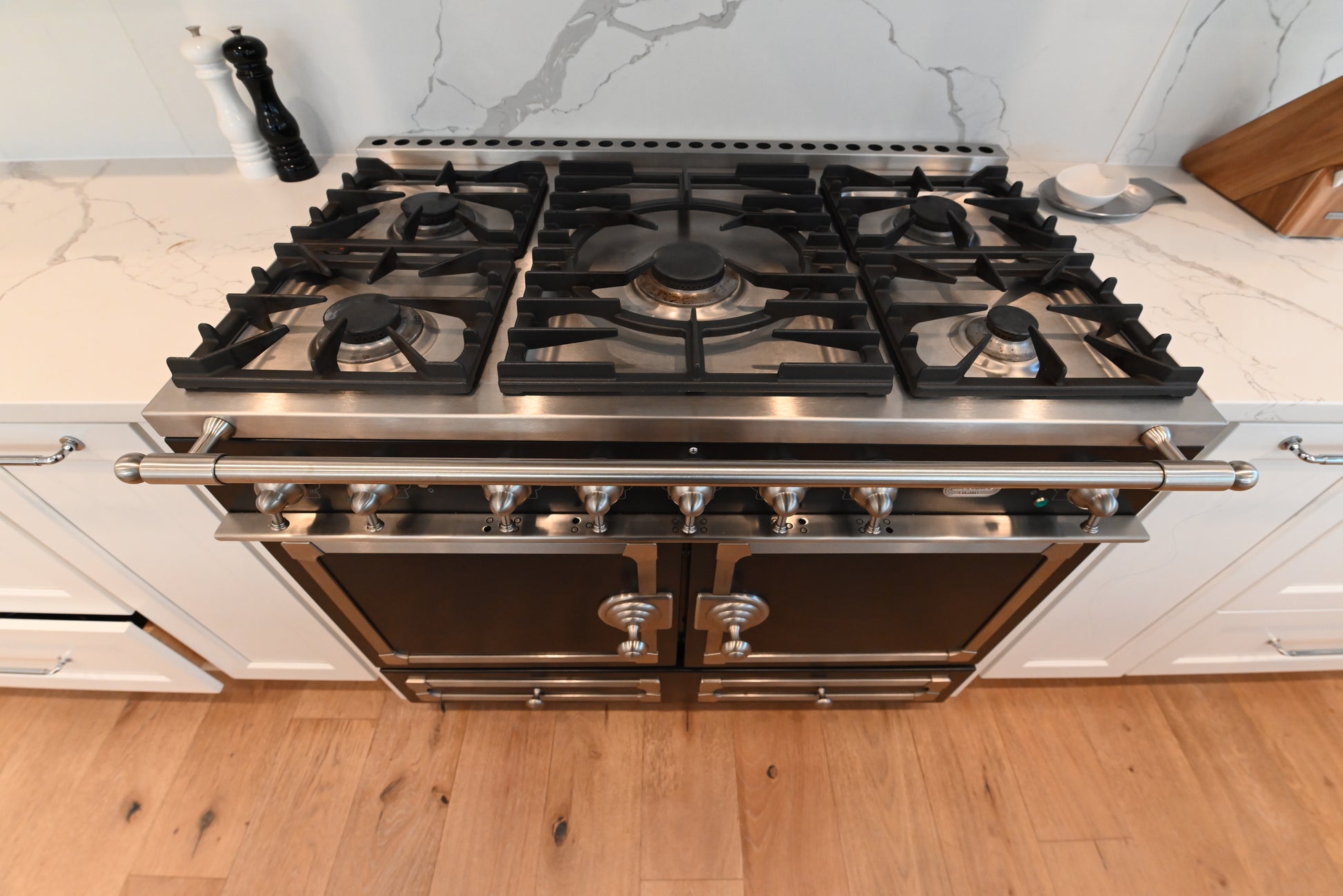Pre owned La Cornue CornuFe matching gloss black range and ventilation hood set installed in luxury estate kitchen