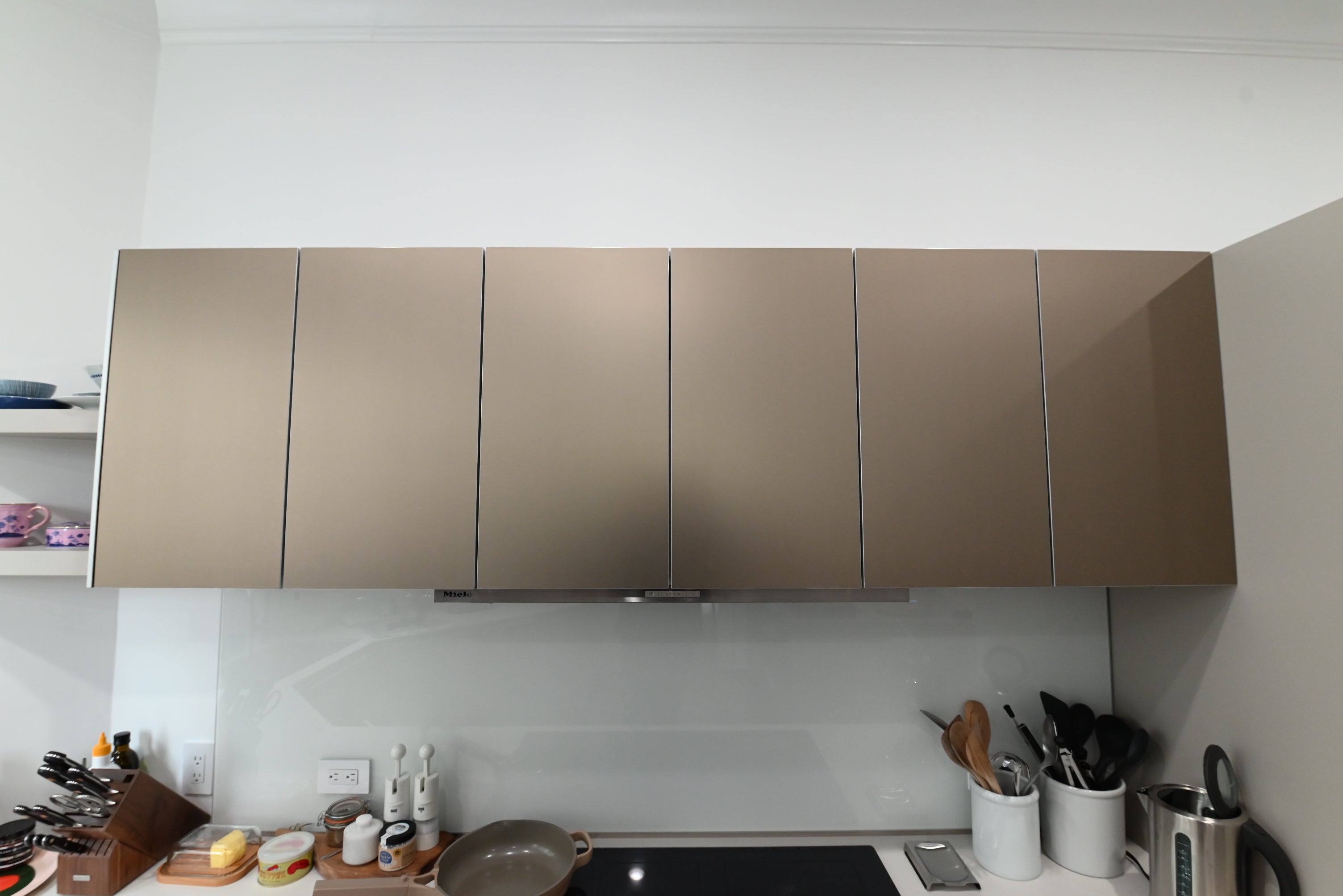 Bulthaup Modern Metallic Bronze Upper Cabinets with Glass Backsplash and Miele Hood Insert