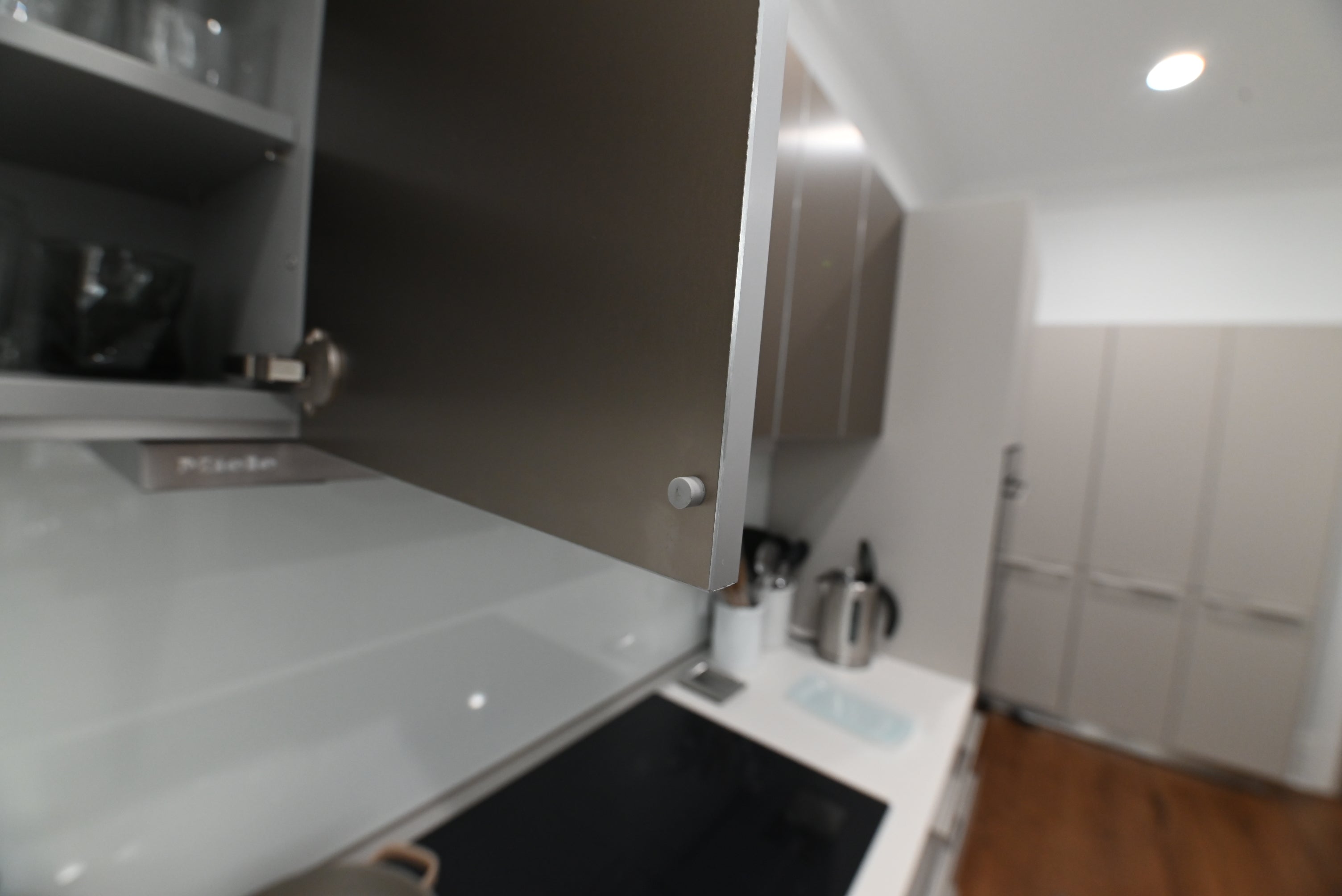 Bulthaup Modern Metallic Bronze Upper Cabinets with Glass Backsplash and Miele Hood Insert