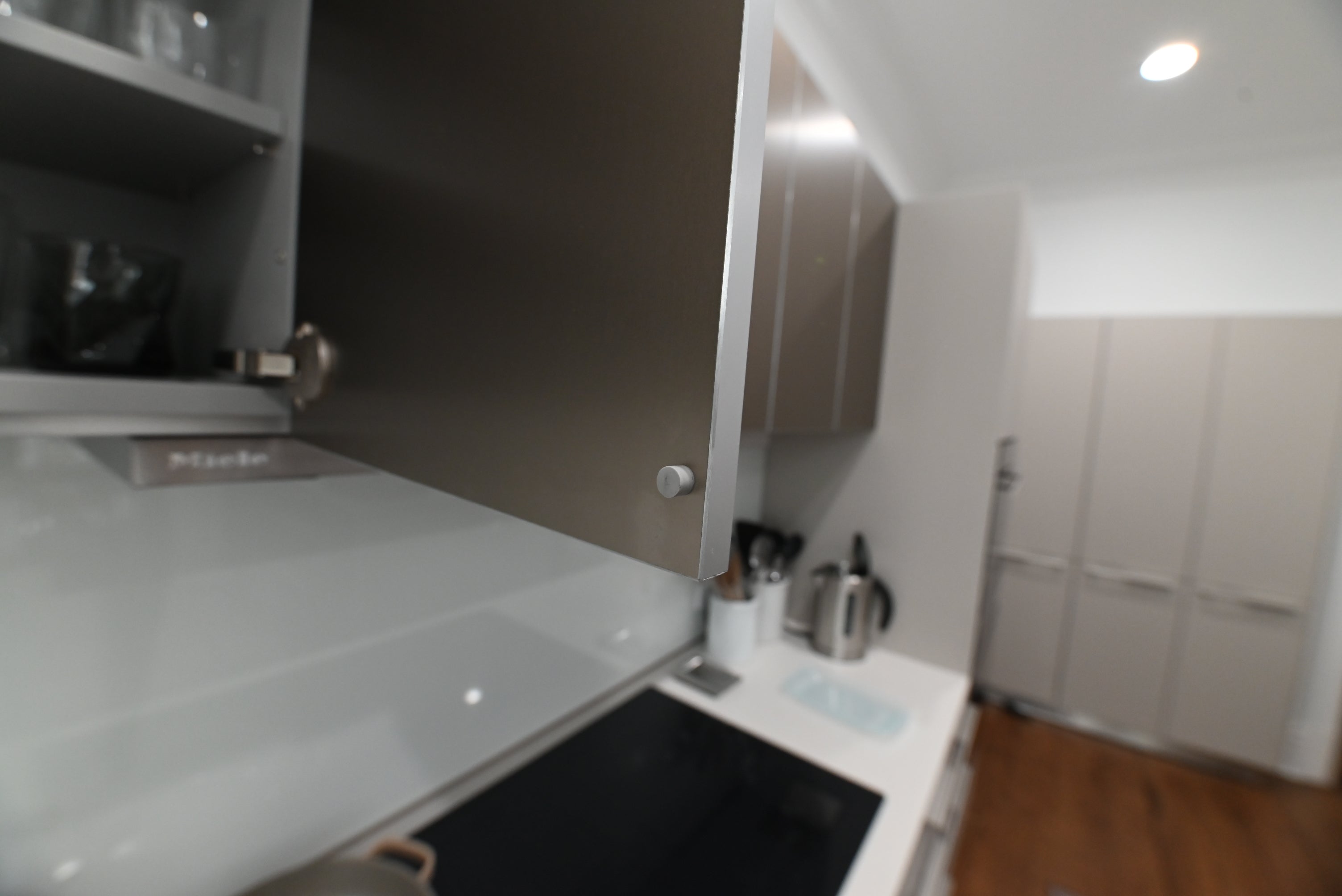 Bulthaup Modern Metallic Bronze Upper Cabinets with Glass Backsplash and Miele Hood Insert