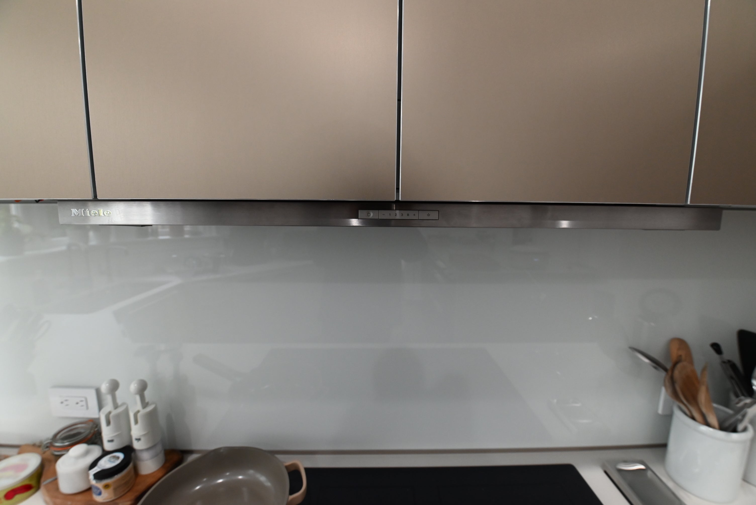 Bulthaup Modern Metallic Bronze Upper Cabinets with Glass Backsplash and Miele Hood Insert
