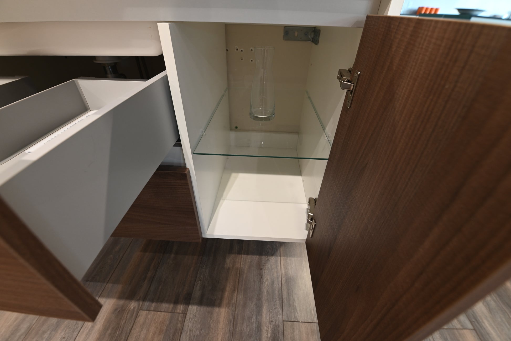 36 inch floating bathroom vanity sitting flush against a concrete textured wall in a minimalist powder room