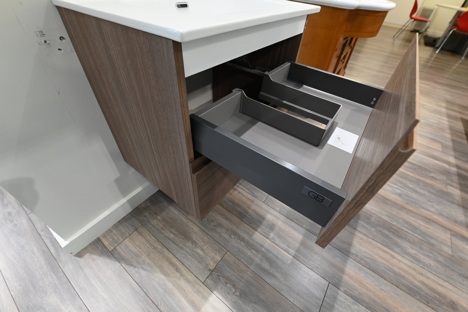 24 inch single basin floating bathroom vanity sitting flush against a tiled wall in a luxury contemporary powder room