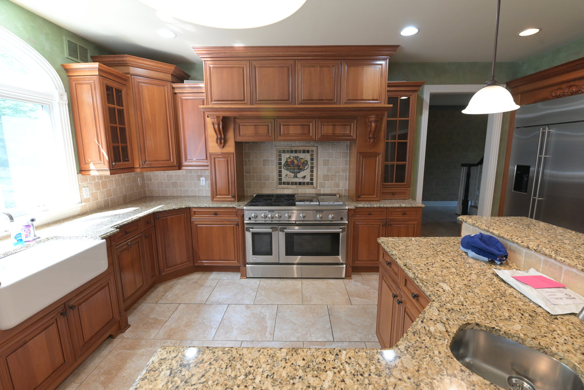 Aurora Circ traditional wooden kitchen with raised panel cabinets stainless steel range granite countertops and island sink