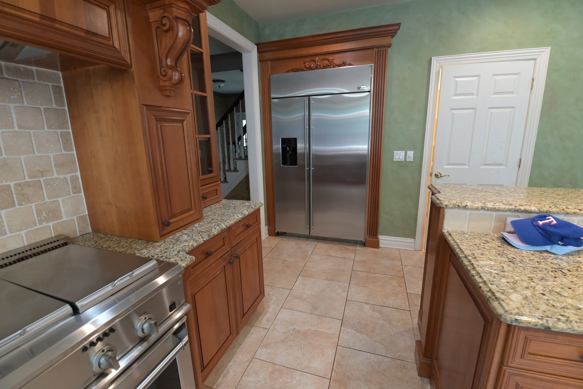 Aurora Circ traditional wood kitchen with carved cabinetry stainless steel range refrigerator and granite countertops