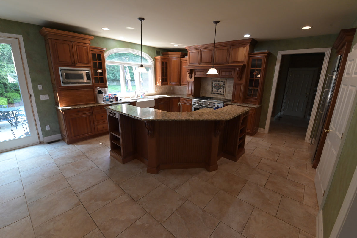 Aurora Circ traditional dark wood kitchen with raised panel cabinetry granite island countertops built in appliances and tiled flooring