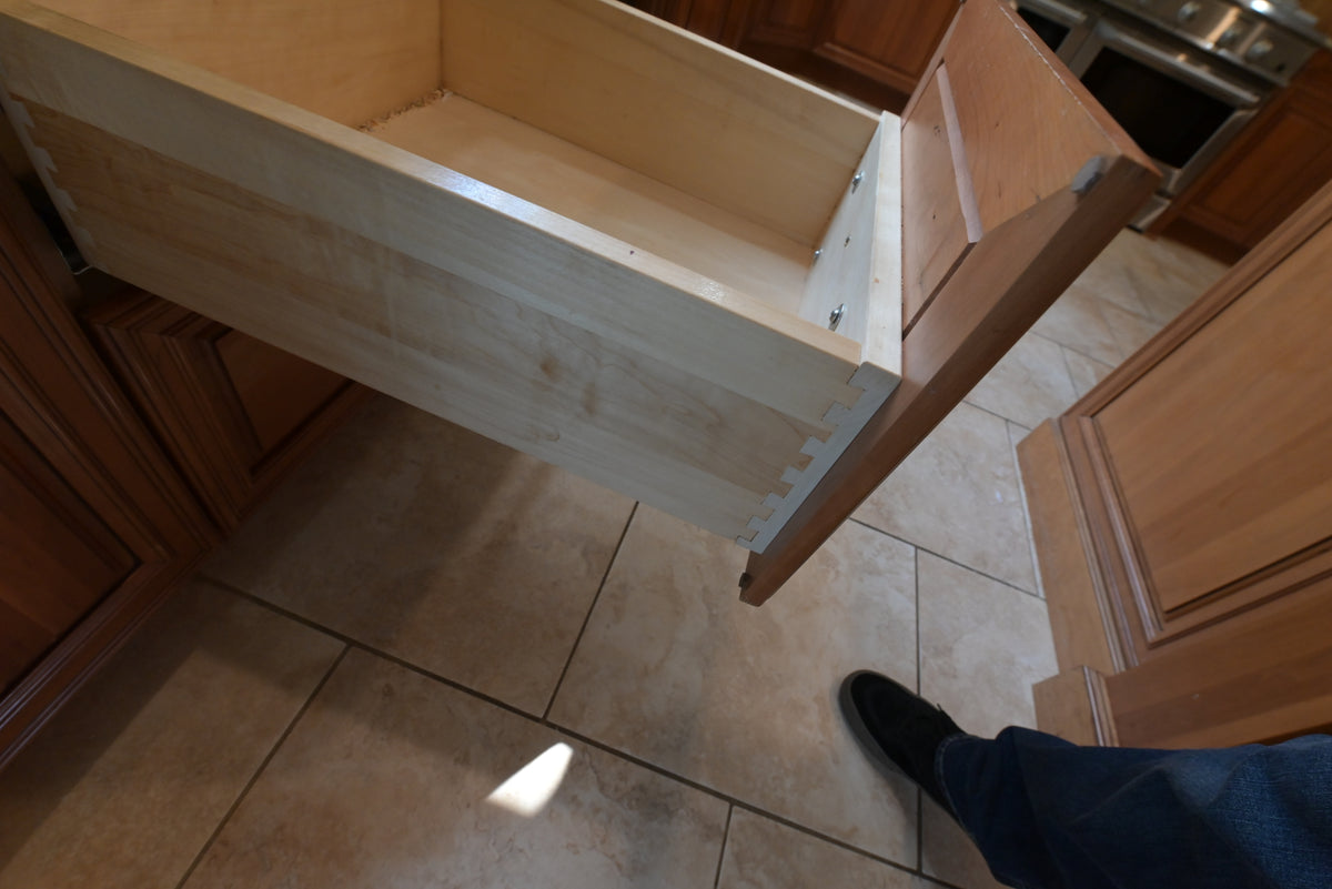 Aurora Circ traditional wooden kitchen drawer opened to reveal a spacious interior and dovetail joinery beside classic cabinetry