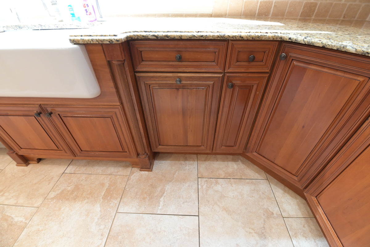 Aurora Circ traditional warm wood kitchen cabinets with raised panel doors farmhouse sink granite countertop and tiled floor