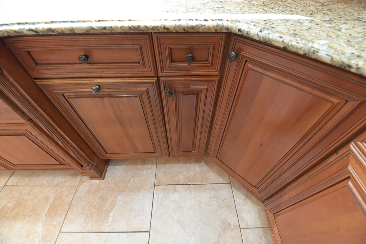 Aurora Circ traditional wooden kitchen cabinets with raised panel doors dark hardware granite countertop and tiled floor