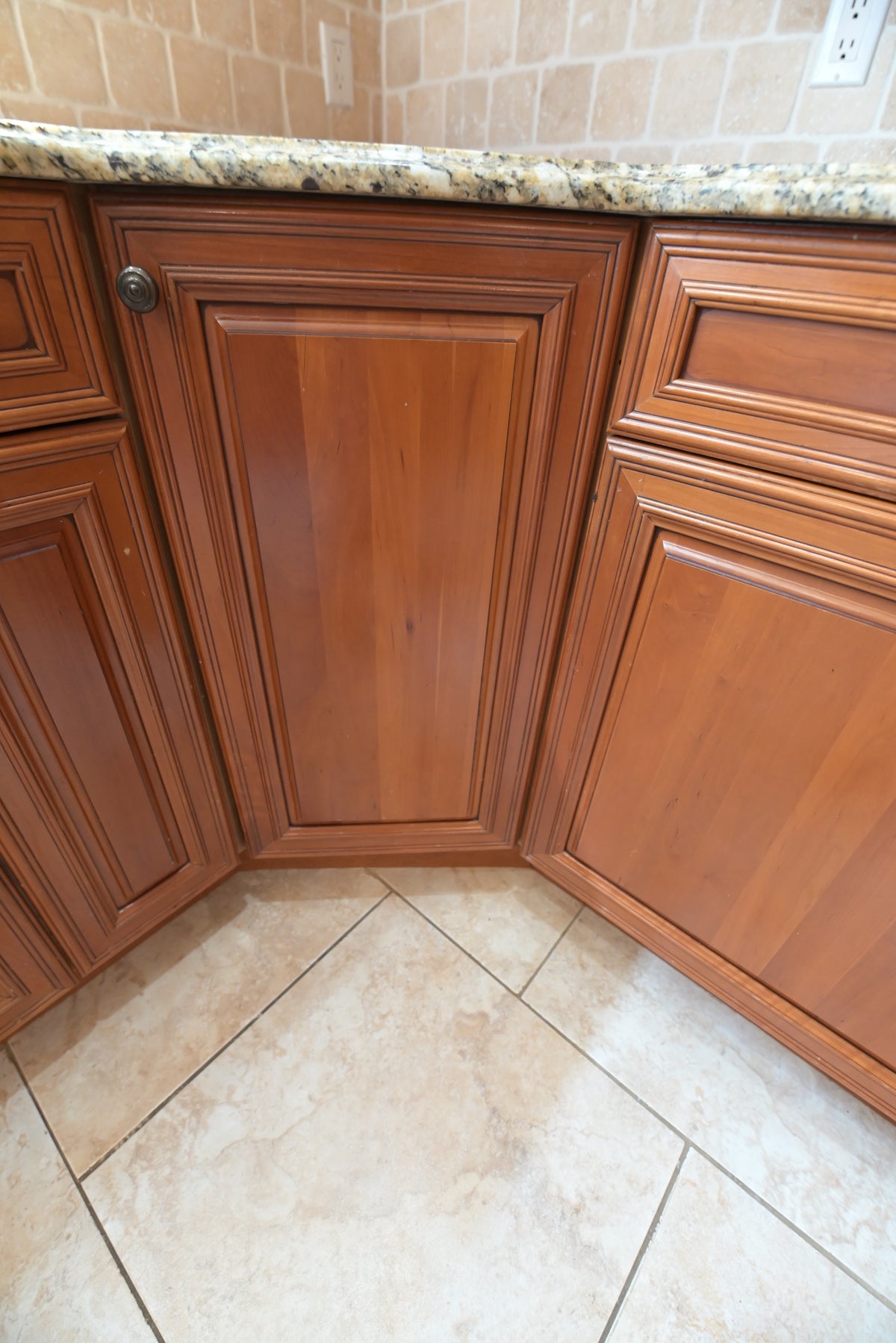 Aurora Circ traditional wooden kitchen cabinets with raised panel doors dark hardware granite countertop and tiled backsplash