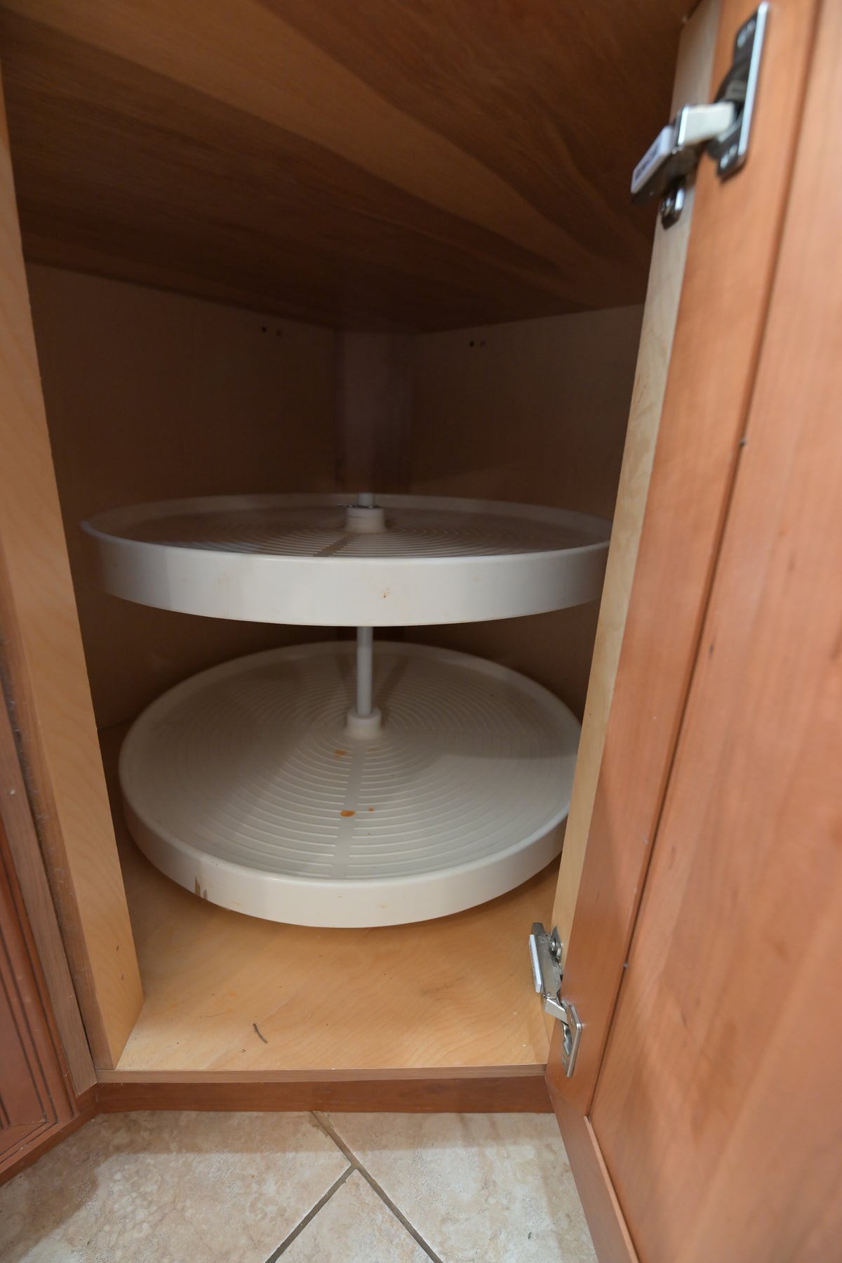 Aurora Circ wooden kitchen cabinet with two tier rotating shelves and an open door above tiled flooring