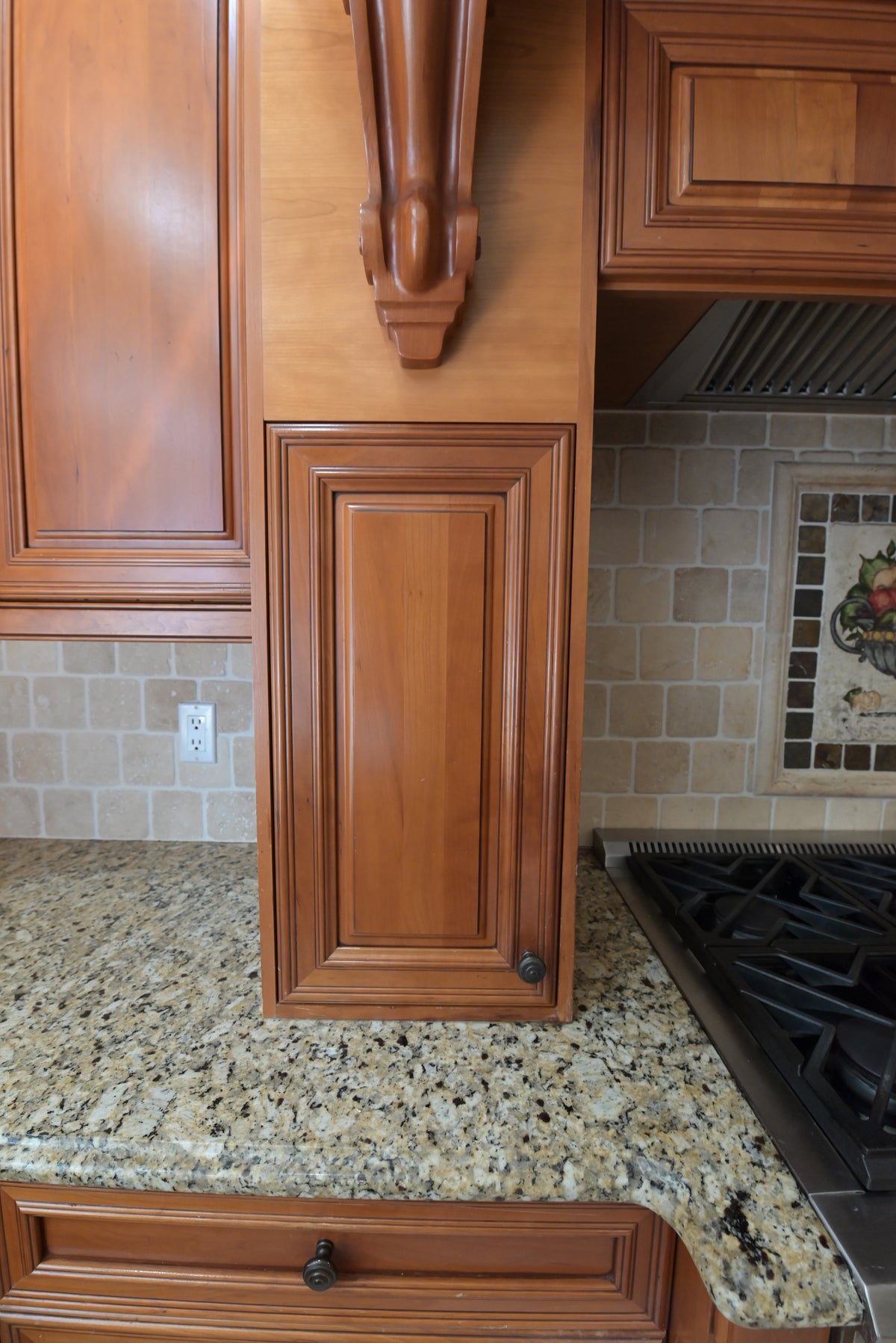 Aurora Circ traditional wood kitchen cabinetry with raised panel doors ornate corbel granite countertop and gas cooktop