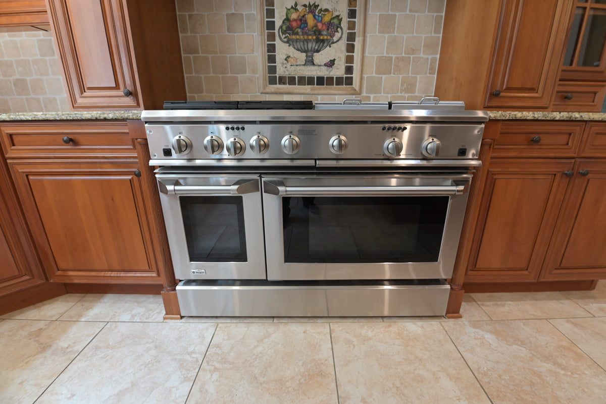 Aurora Circ traditional wooden kitchen with a stainless steel range featuring double ovens and multiple front controls
