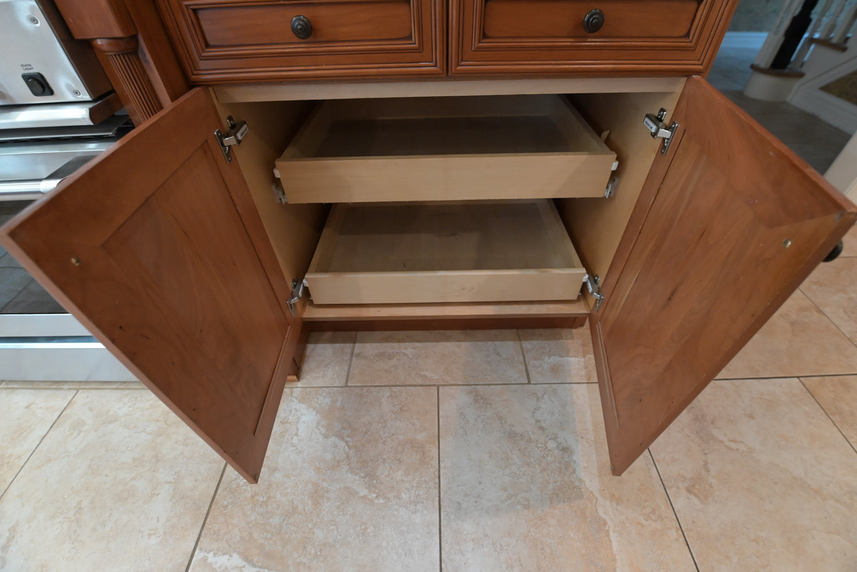 Aurora Circ traditional wooden kitchen base cabinet with open doors and two pull out shelves above tiled flooring