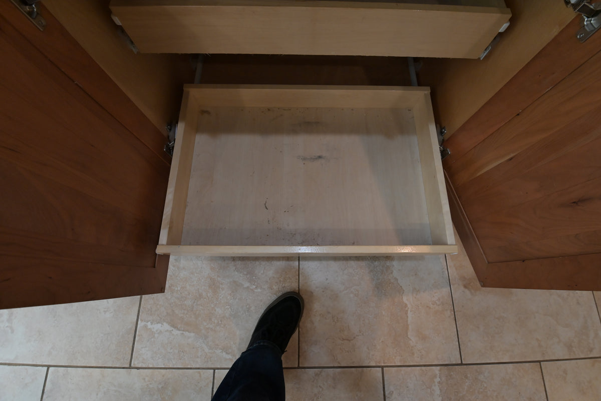 Aurora Circ traditional wooden kitchen cabinet with an open drawer and tiled floor