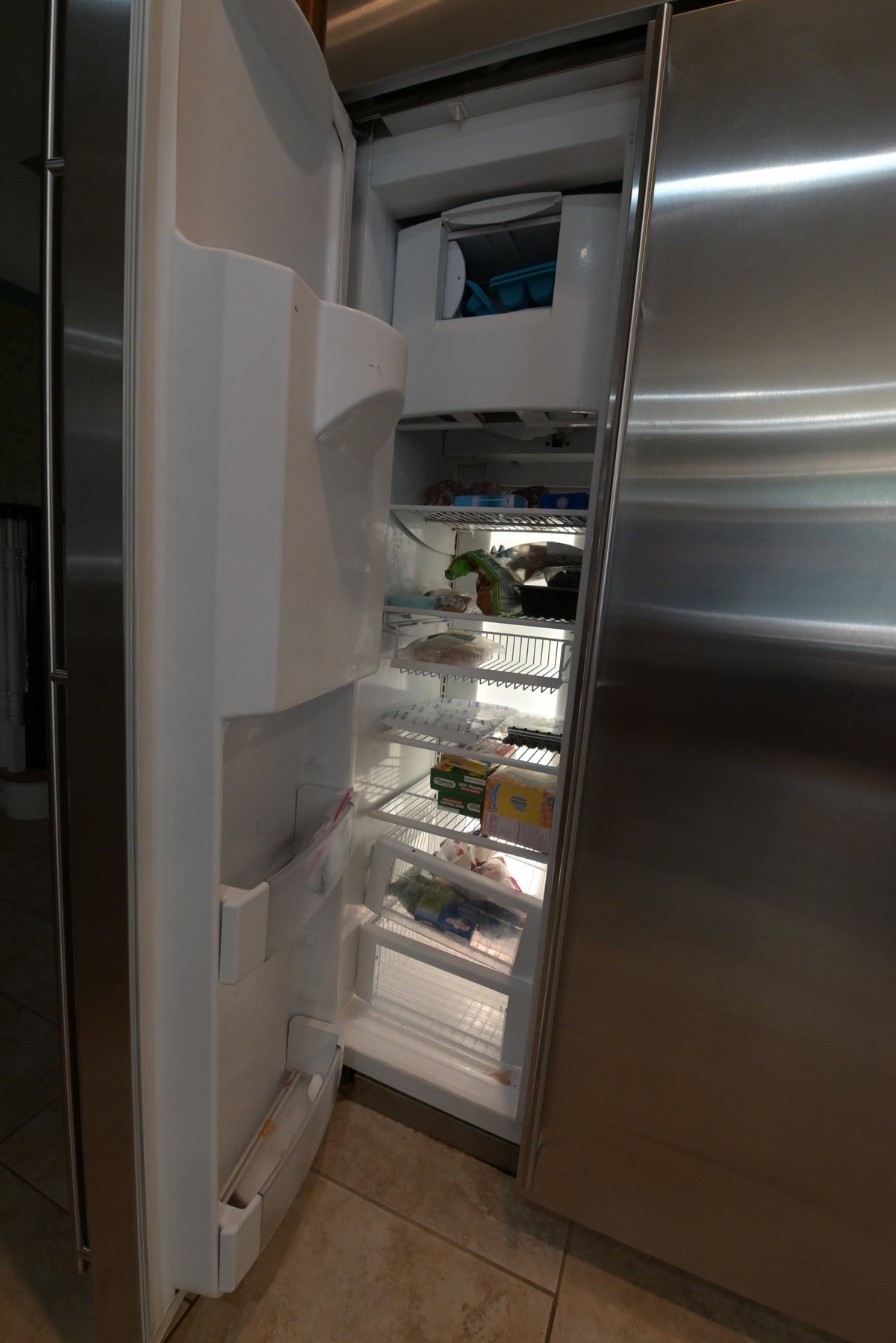 Aurora Circ stainless steel refrigerator with open door revealing adjustable shelves door bins and organized food storage