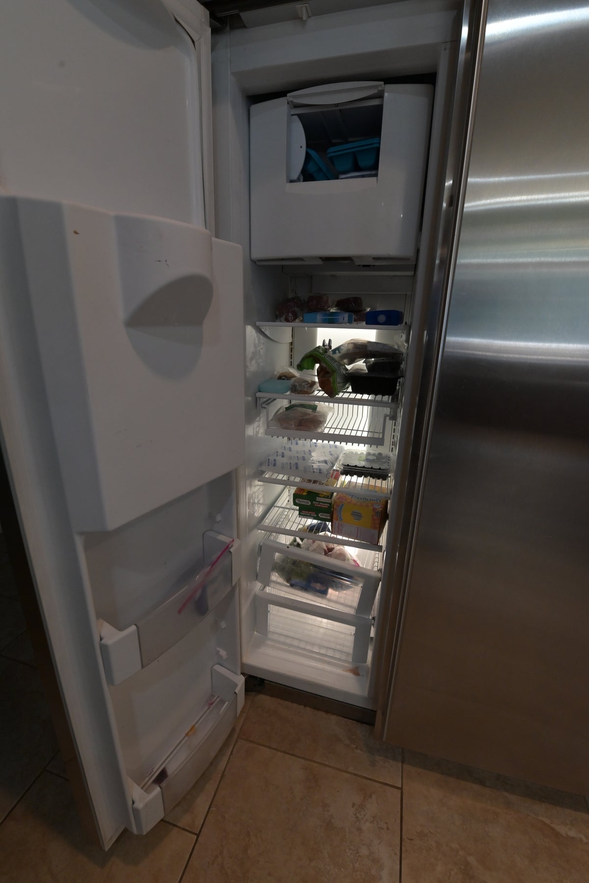 Aurora Circ stainless steel refrigerator with open freezer compartment glass shelves door bins and interior food storage